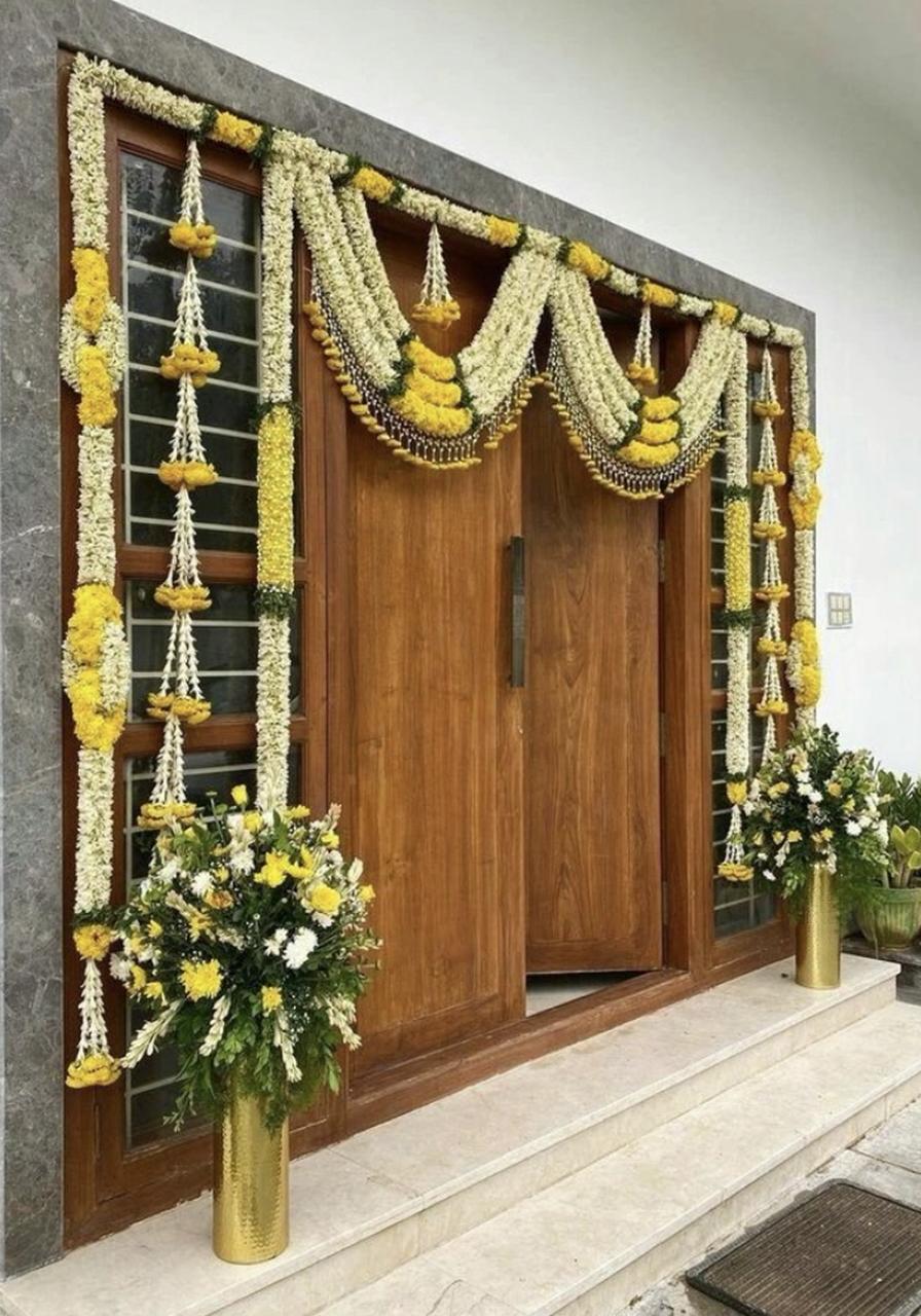A serene outdoor seating area with two chairs, surrounded by lush greenery and a glassed-in structure.