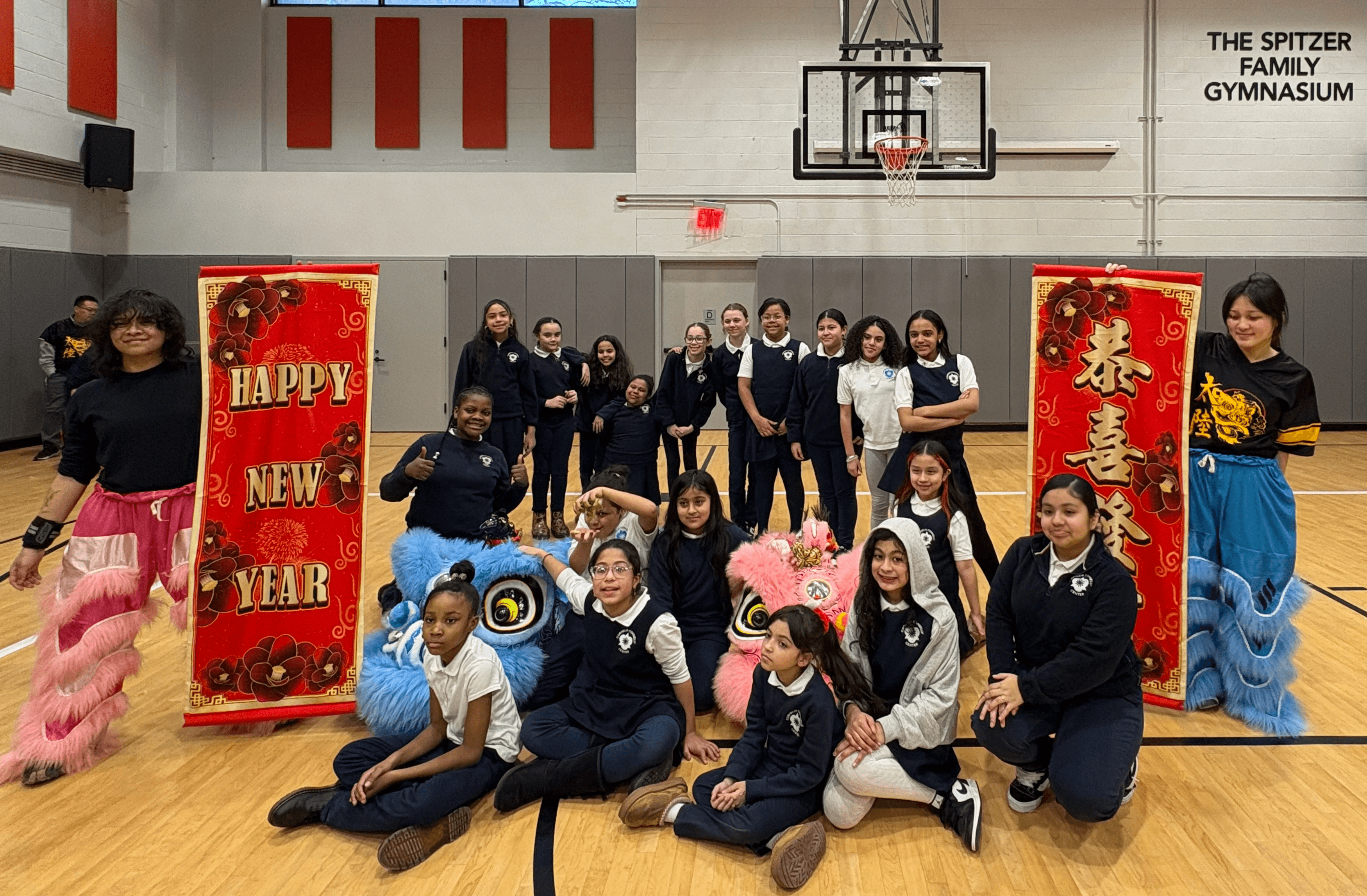 Youth participants pose for a group photo with lion dancers for Lunar New Year.