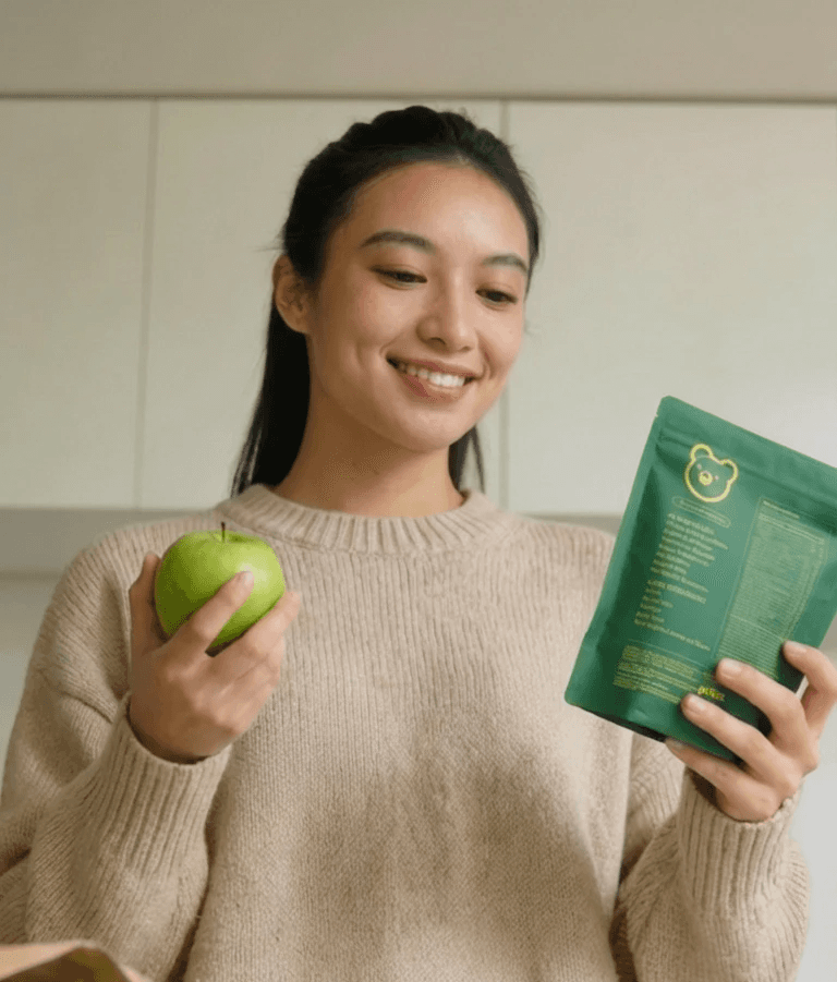 A woman in a white dress and veil posing in a vast desert landscape.