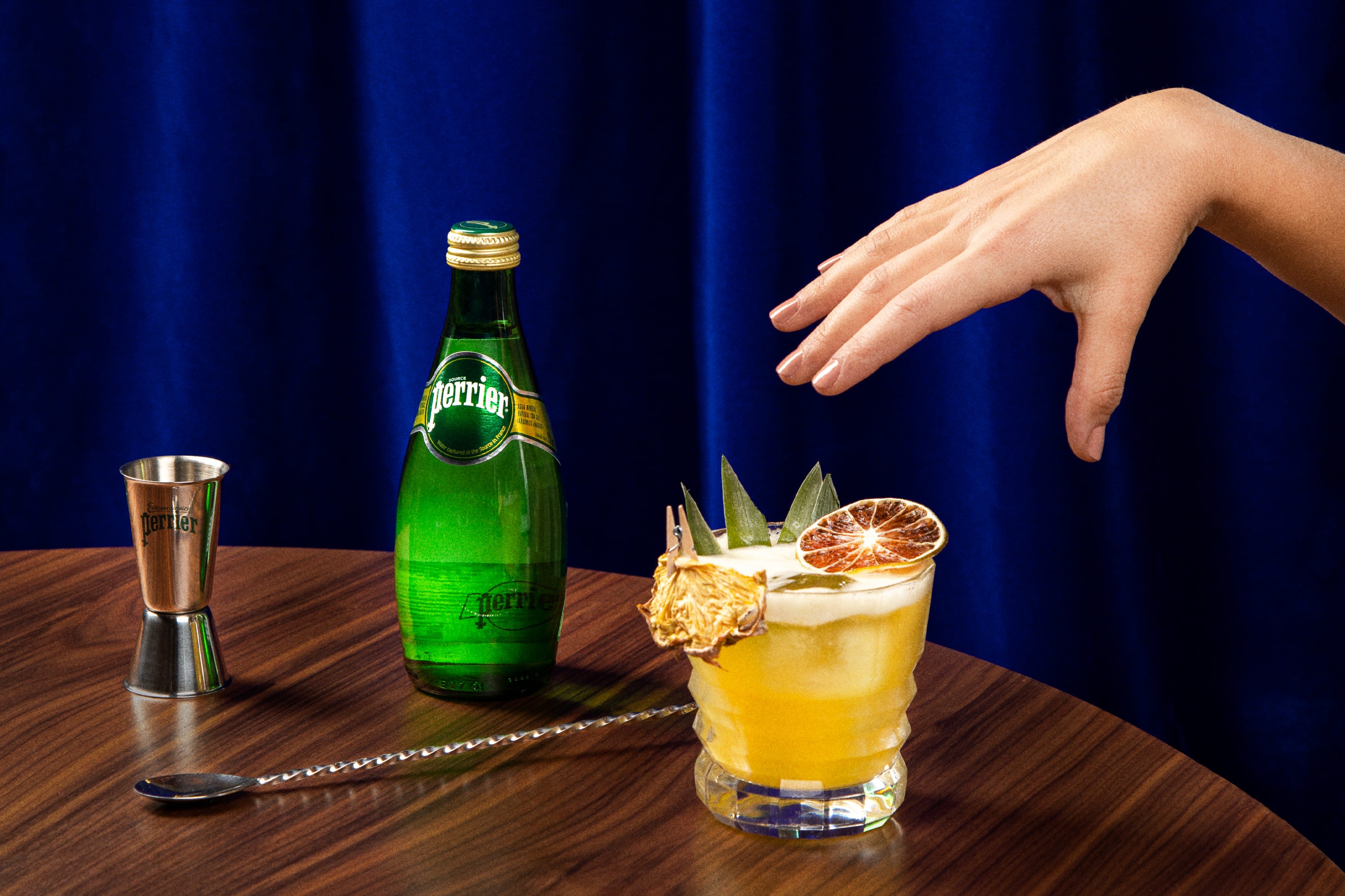 perrier bottle with cocktails and hands