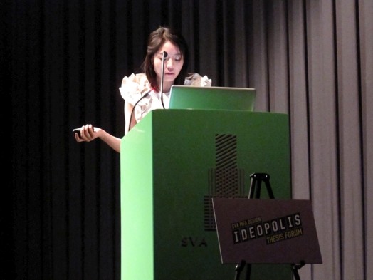 a young lady giving a speech from a green stand