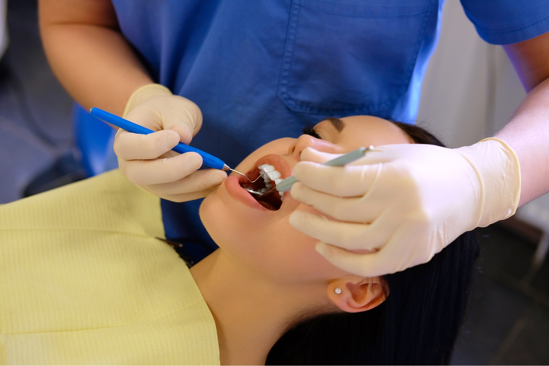 Dentist performing a filling procedure on a patient with dental tools.