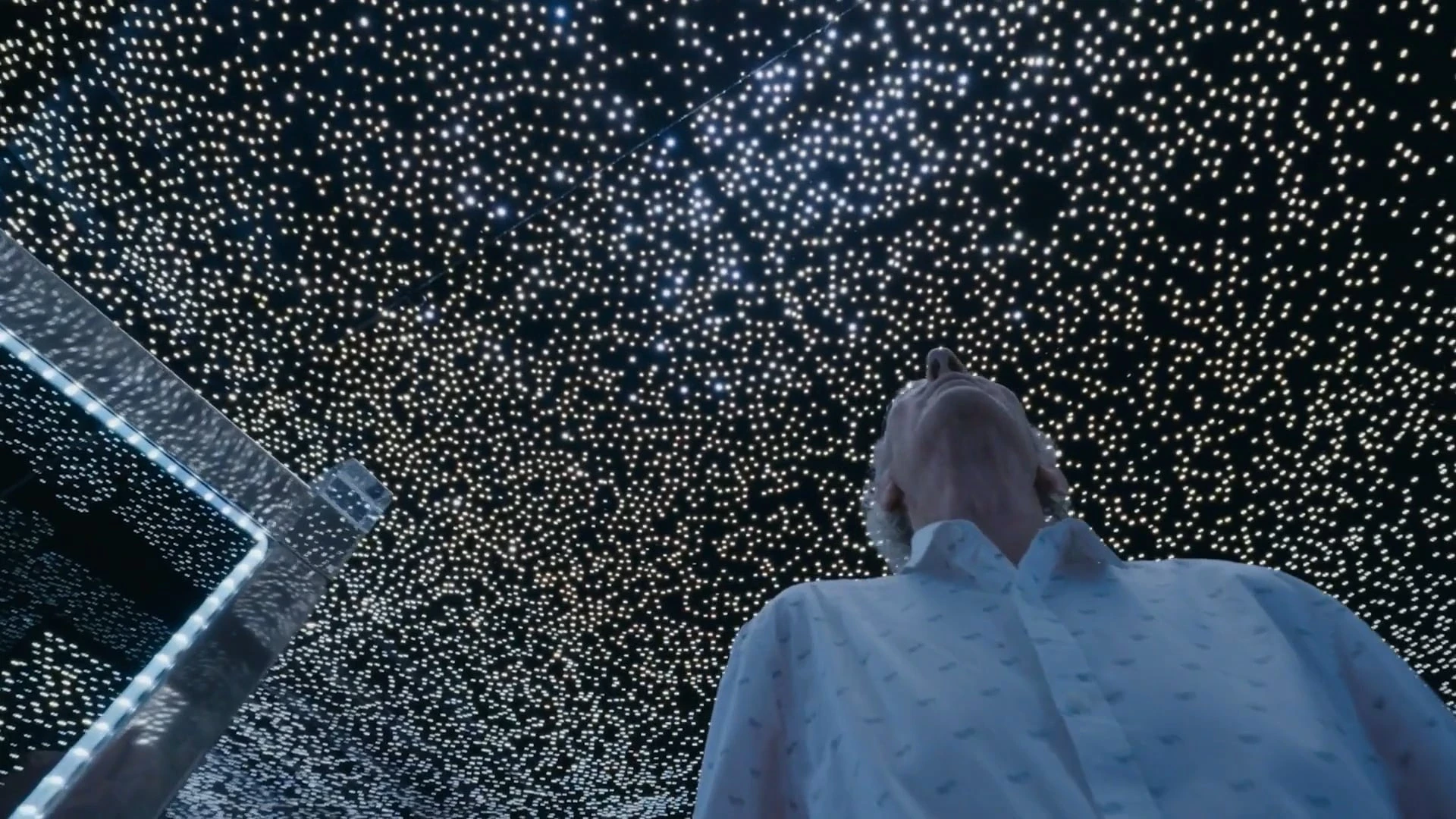 an old man stares into a starred ceiling