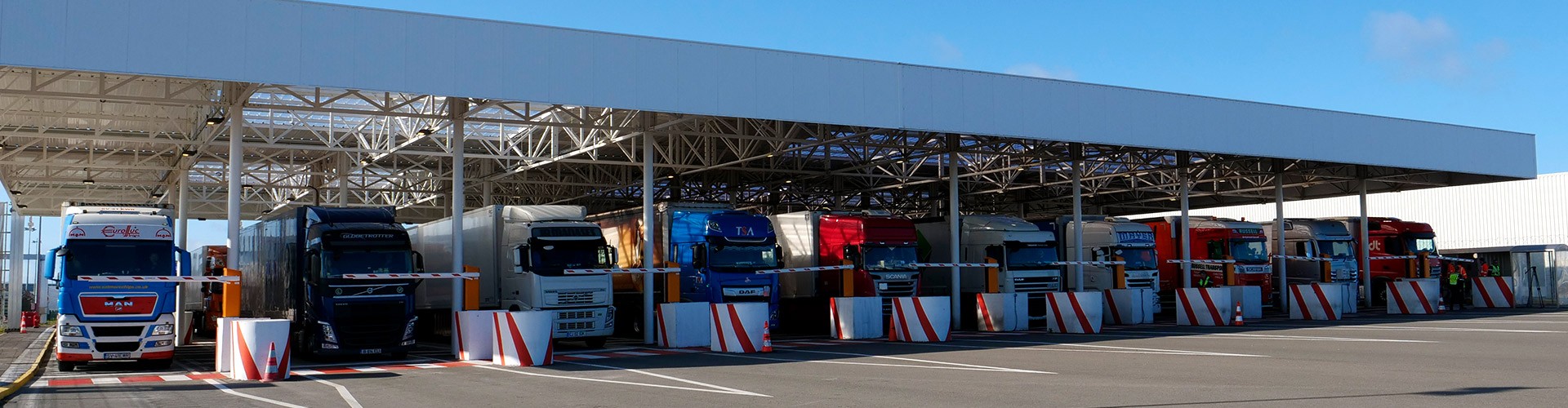 Freight trucks at a UK-EU border crossing, highlighting the ongoing delays in post-Brexit border control implementation.