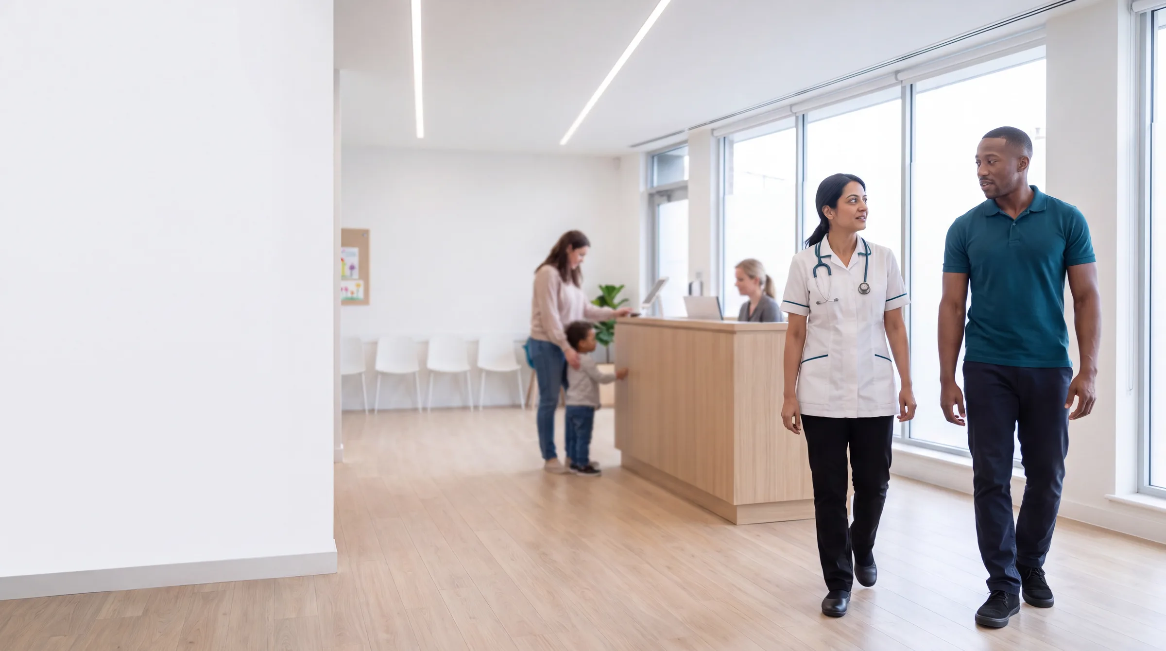 Two Halden clinicians walking through the bright reception while a family checks in