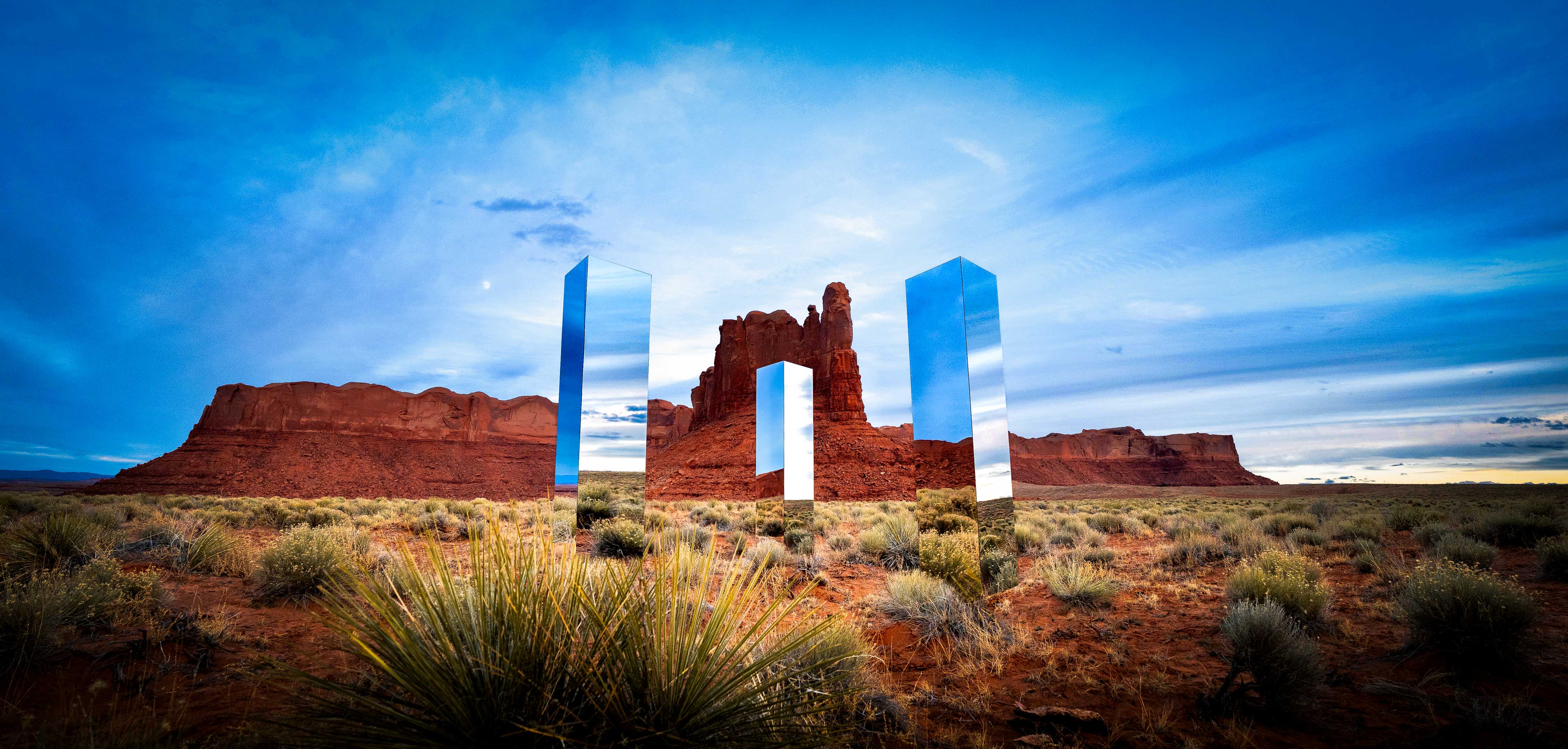 The band A R I Z O N A next to mirror art created by Owen Brown that was inspired by the Utah monolith