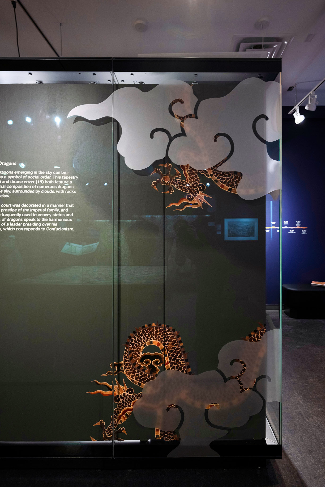 the side of a museum exhibit vitrine that has some frosted glass in the shape of a cloud on the glass