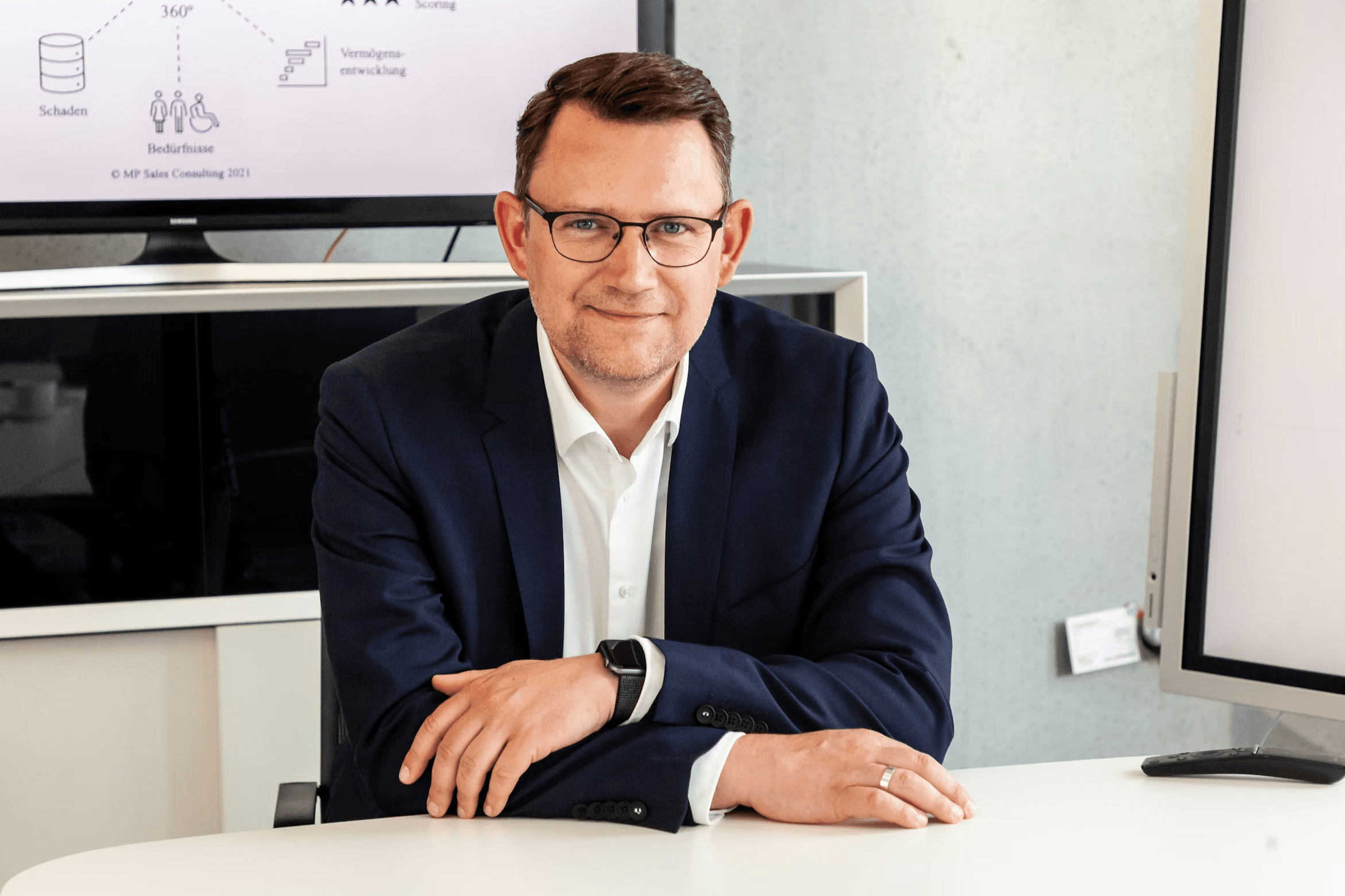 man in gray suit jacket smiling
