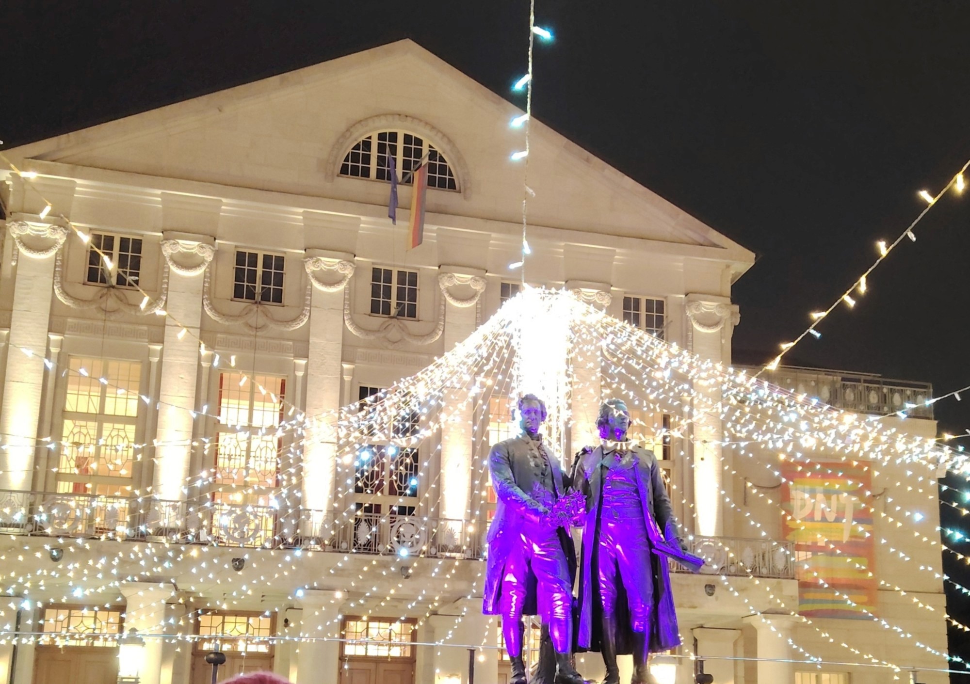 Goethe-Schiller Monument in front of the German National Theatre in Weimar, lit by fairy lights in the evening