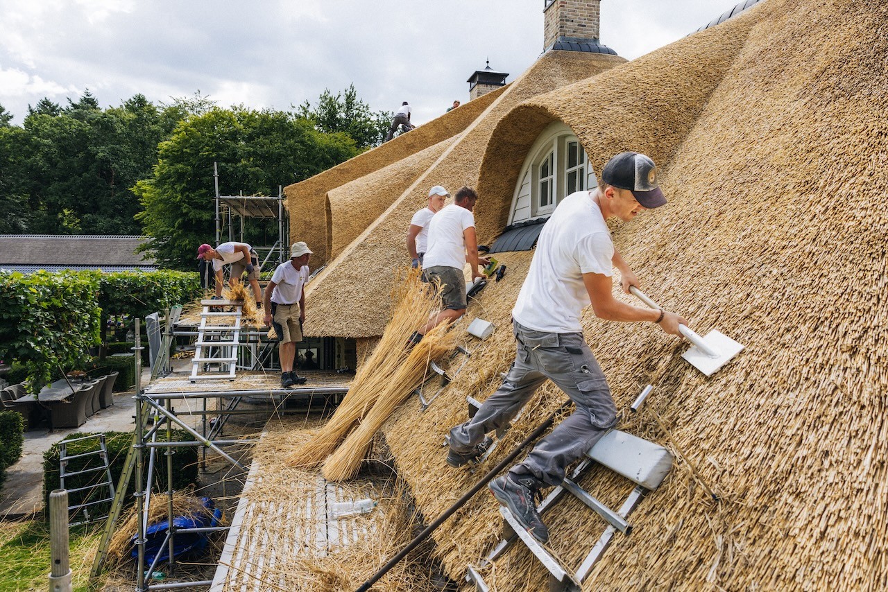 Rietdekkers van Rietdekkersbedrijf van Dijk Putten aan het werk op het dak