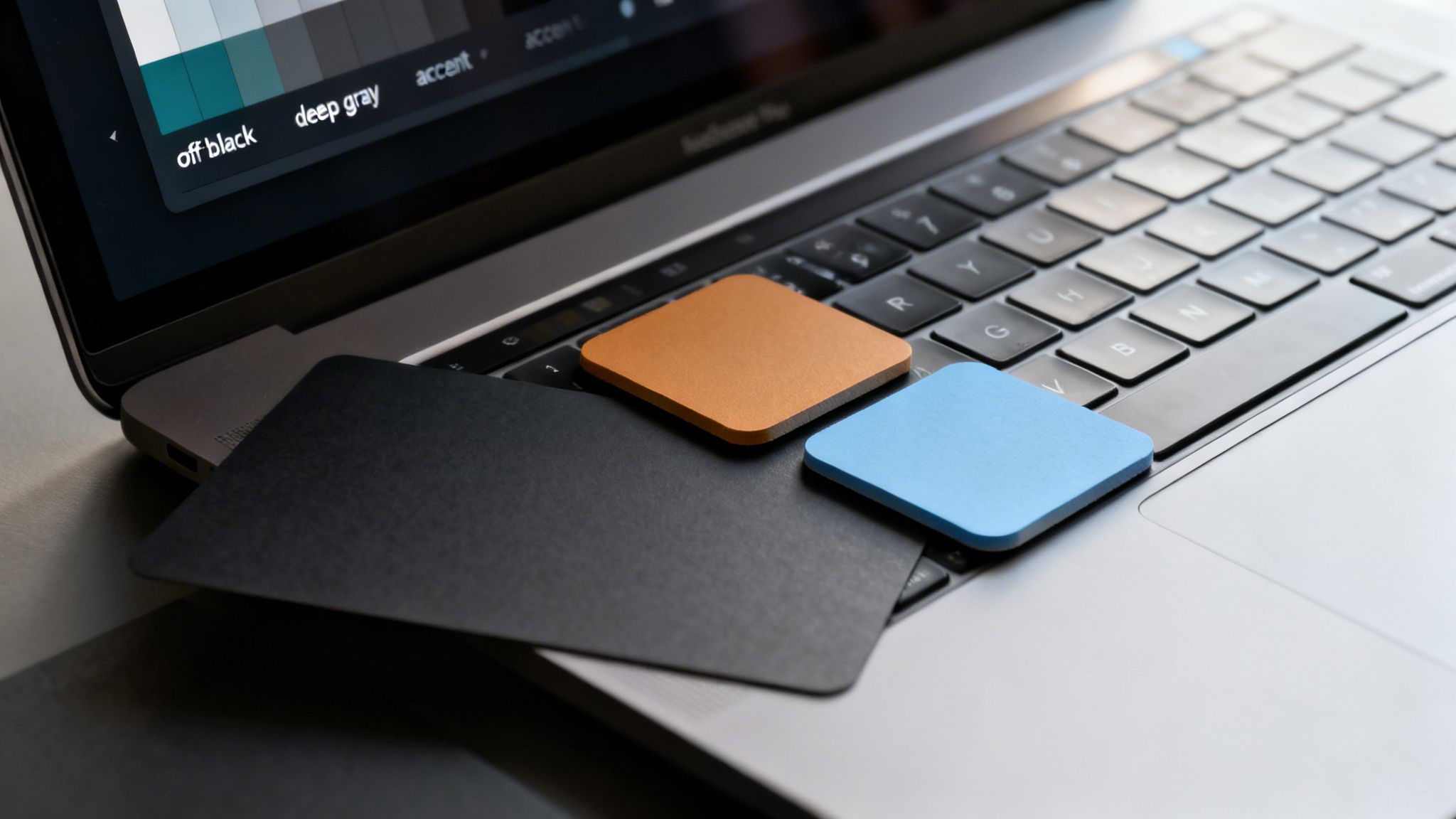 Laptop screen shows 'off black' and 'deep gray' color options, with physical black, orange, blue swatches.