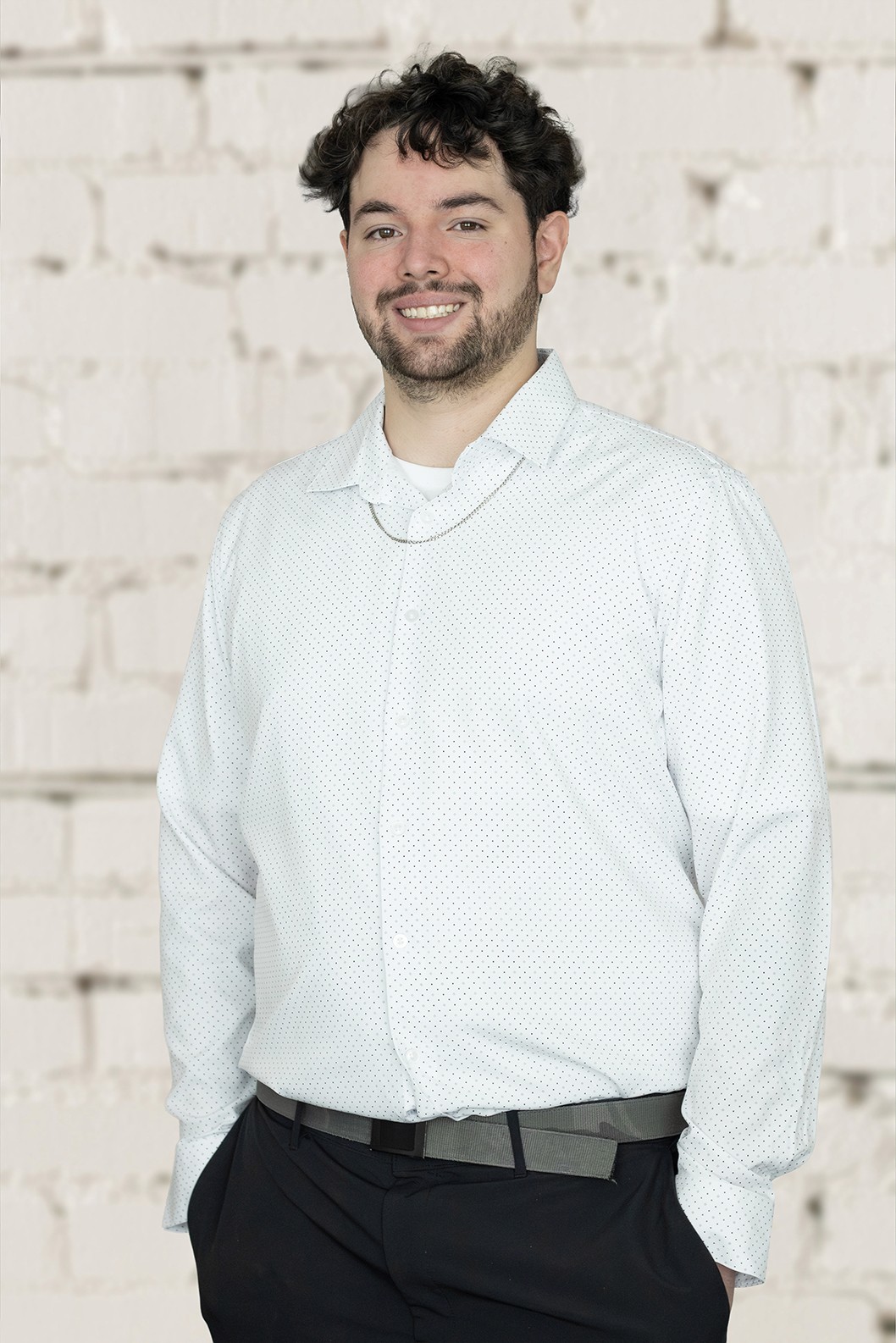 Image of a young man with fair skin and dark hair smiling at the camera.