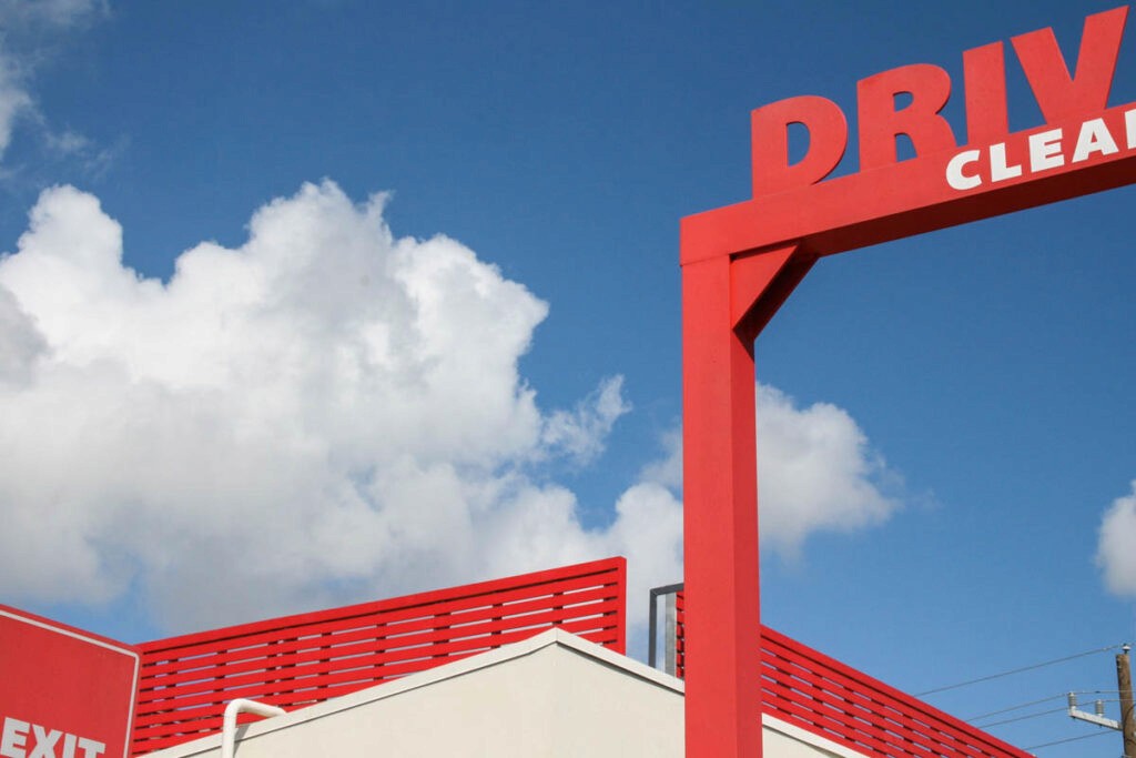 red building structure with sky and white fluffy clouds
