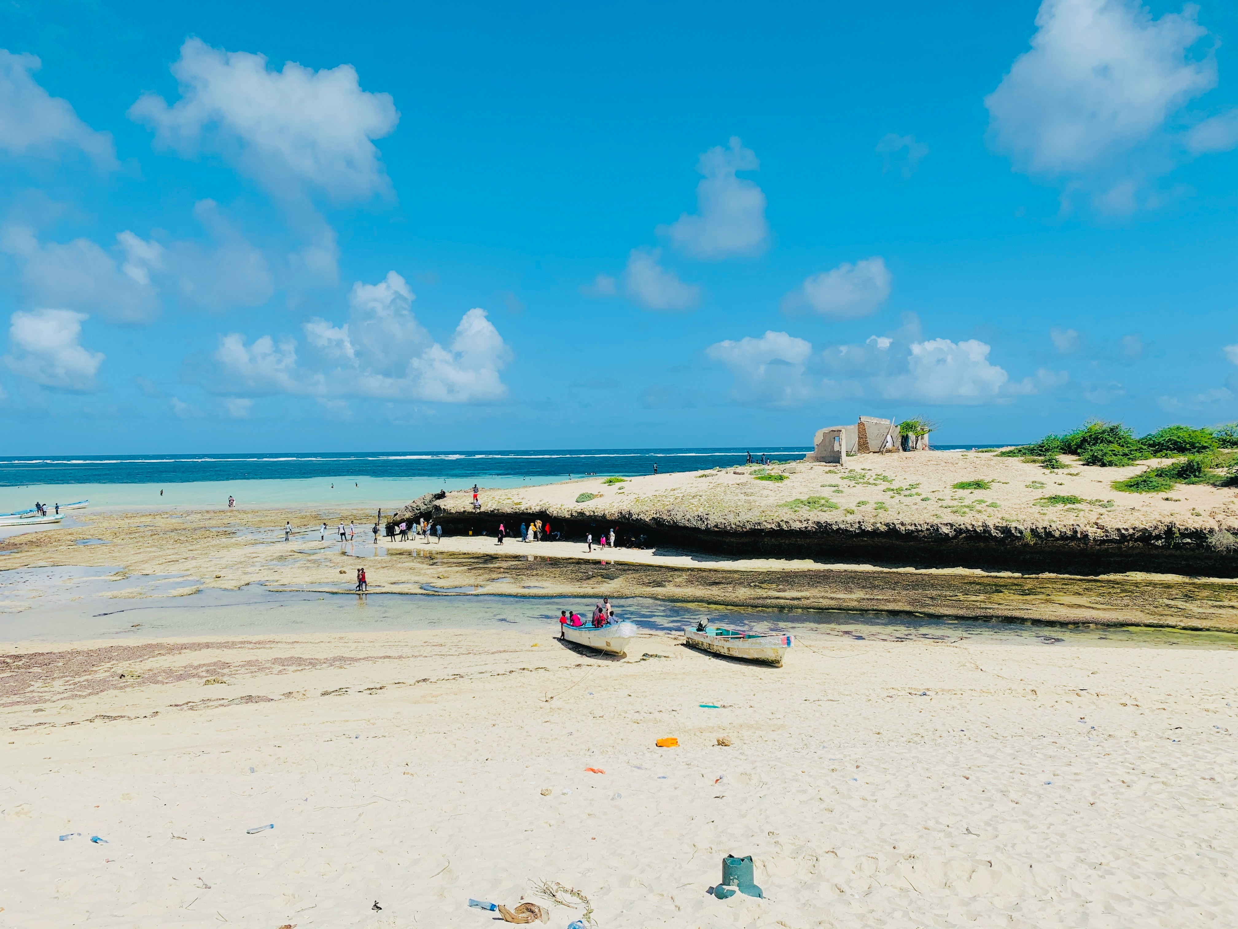 a beach with boats and people