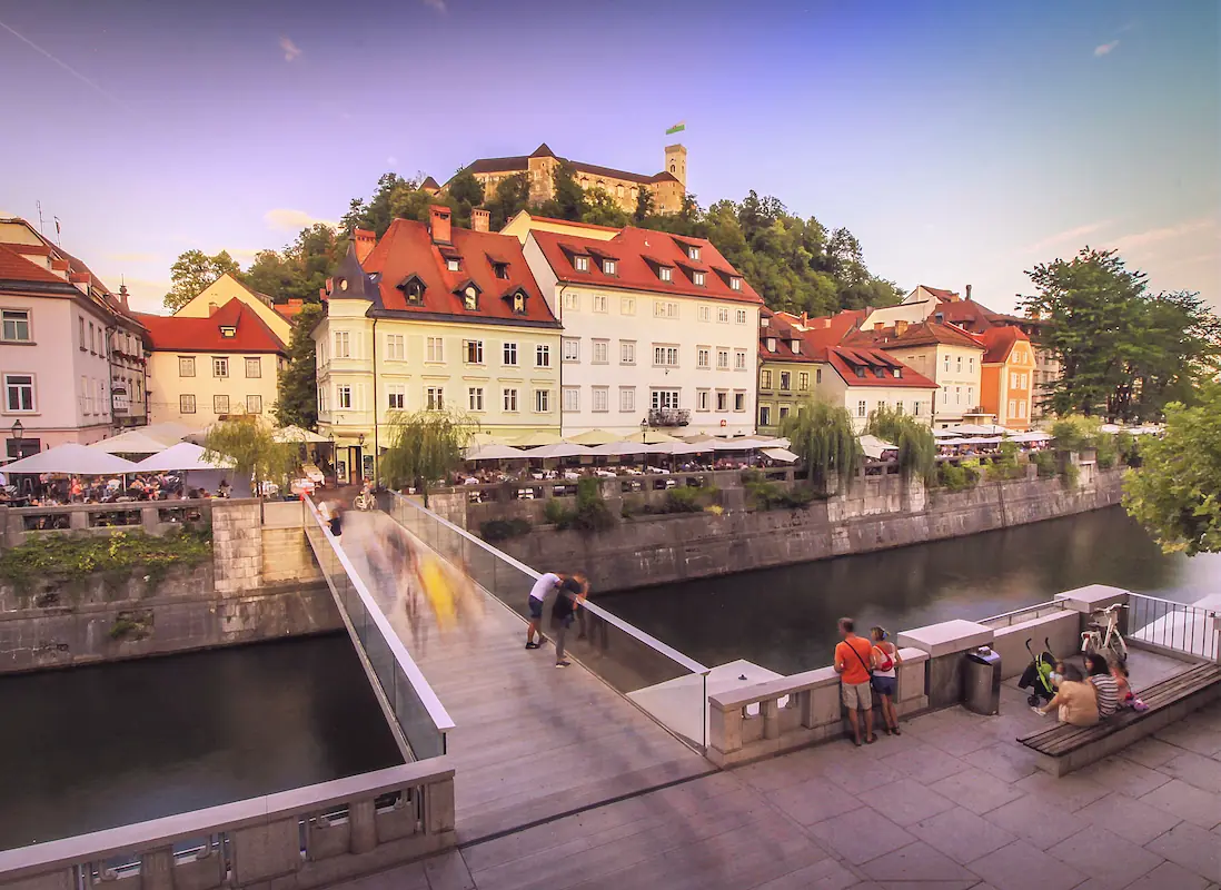 Evening sunlight on Ribja brv bidge in Ljubljana city center, with Ljubljana castle watching over the city from the hill above.