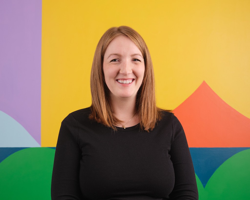 Portrait of Lillian Harder standing in front of a colourful mural