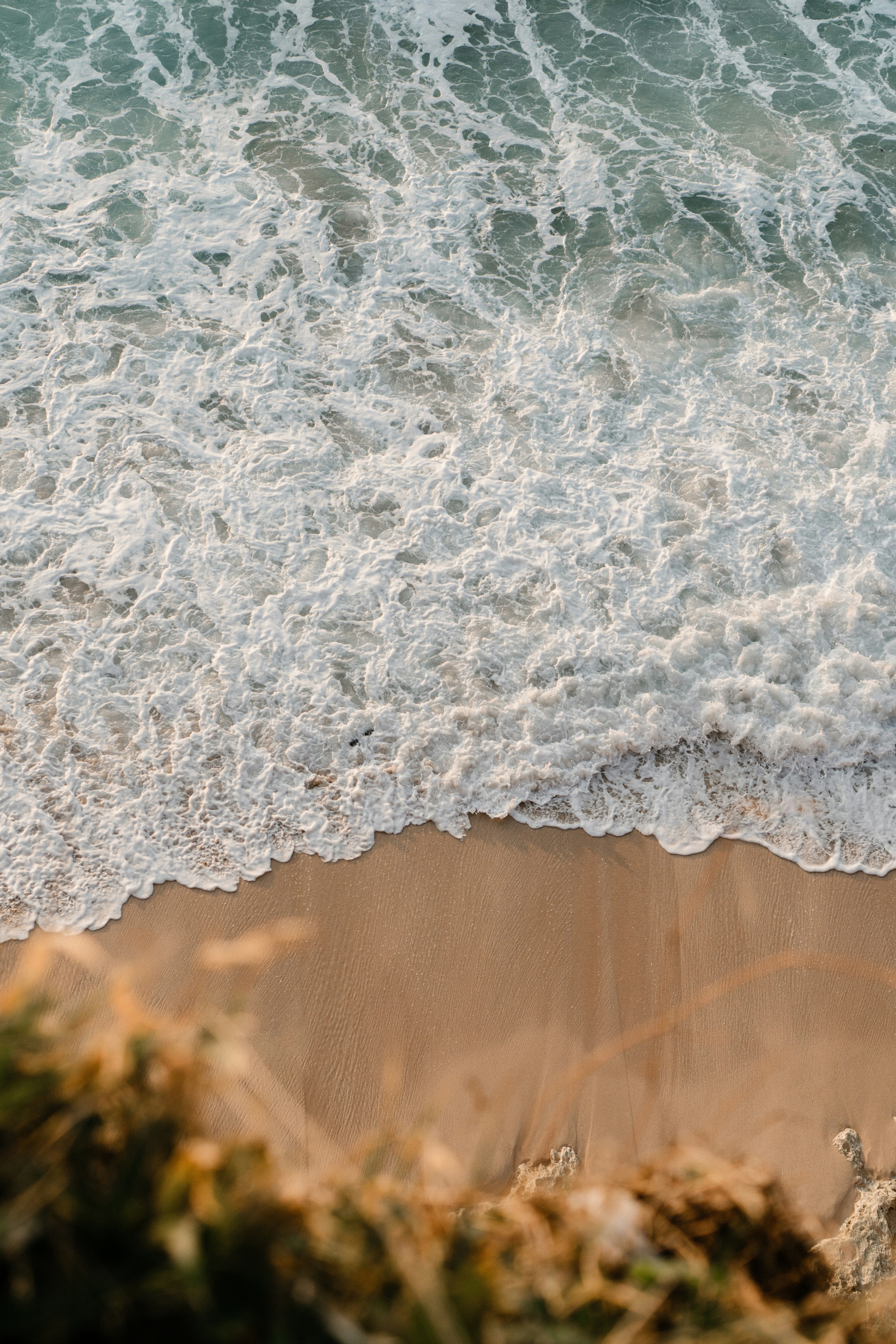 Ocean waves crashing on a sandy beach.
