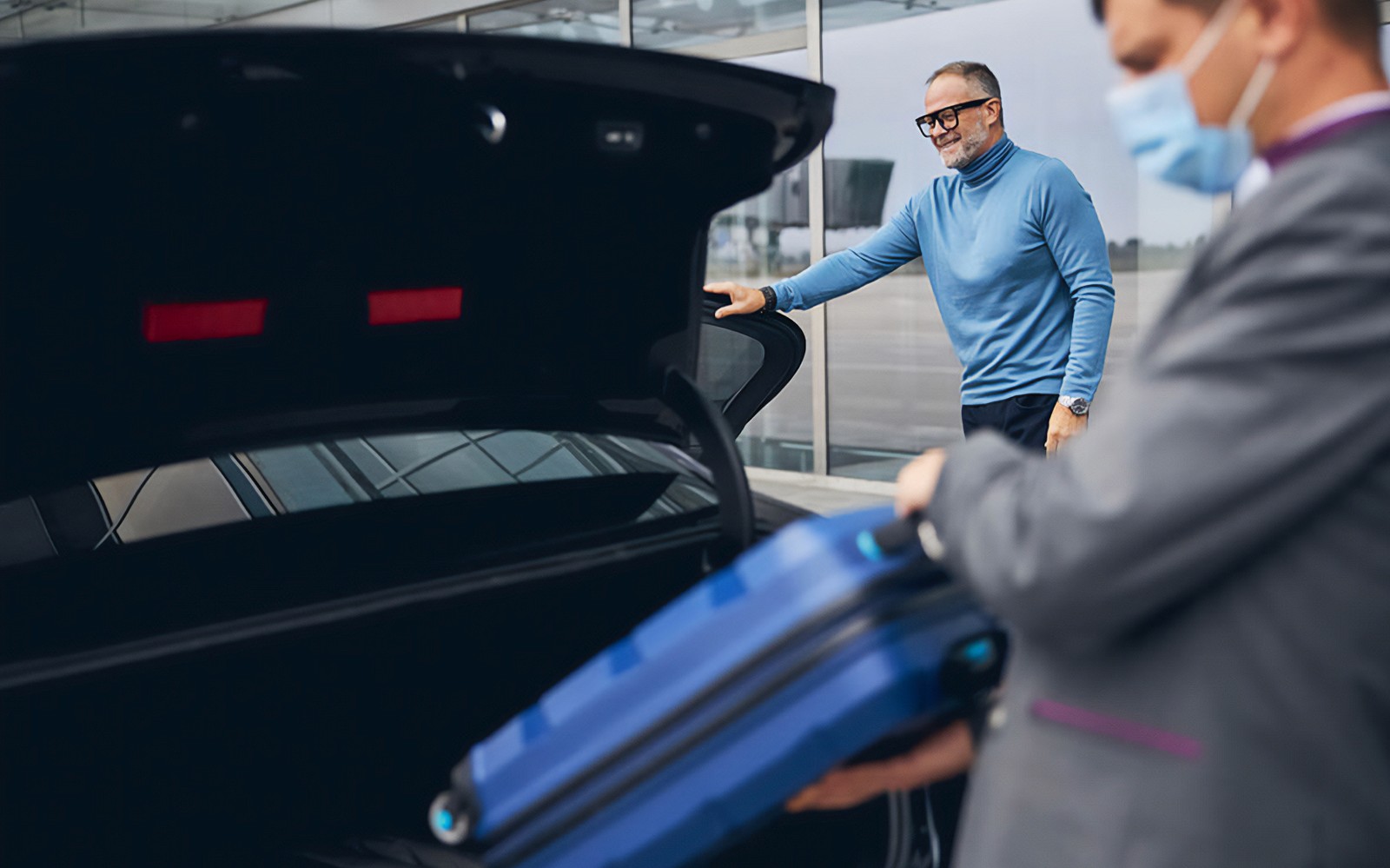 رجل يحمل الأمتعة في صندوق السيارة لنقل مطار كابادوكيا.