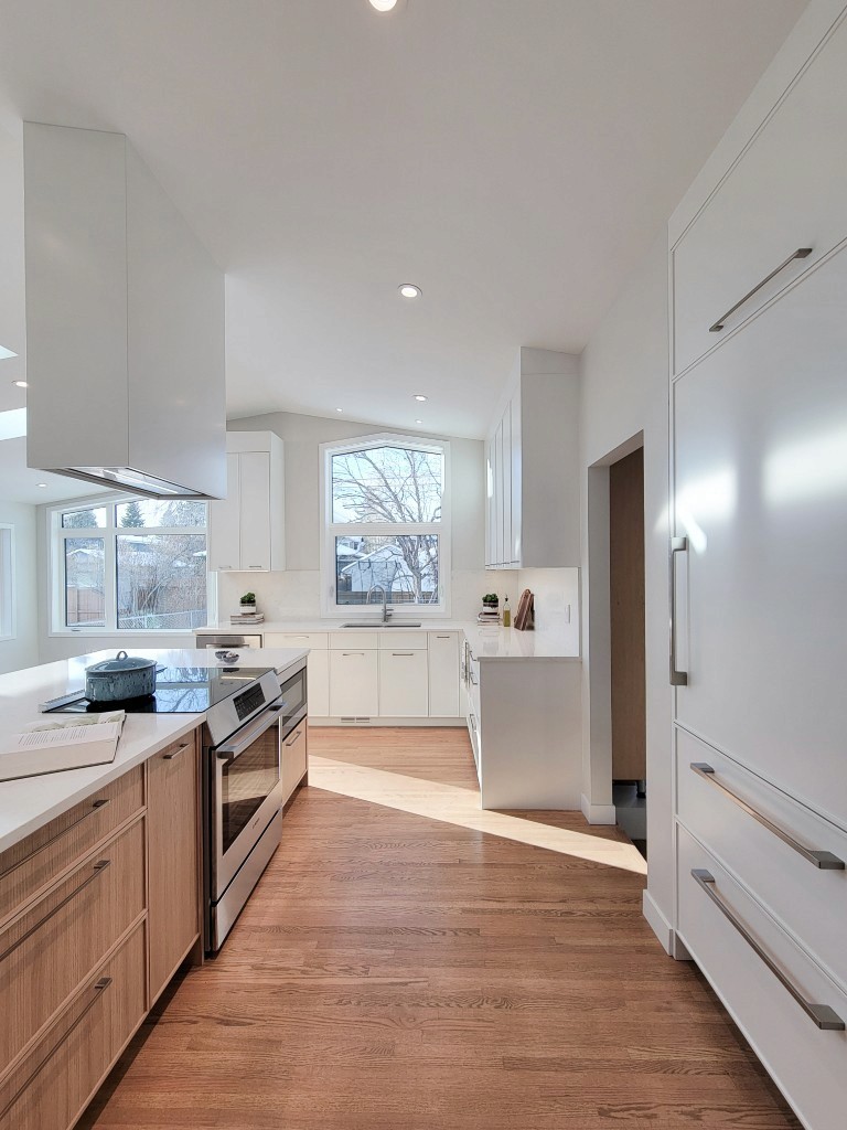 Image of Modern kitchen design with white cabinets, stainless steel appliances, and wooden accents by KHD Homes.