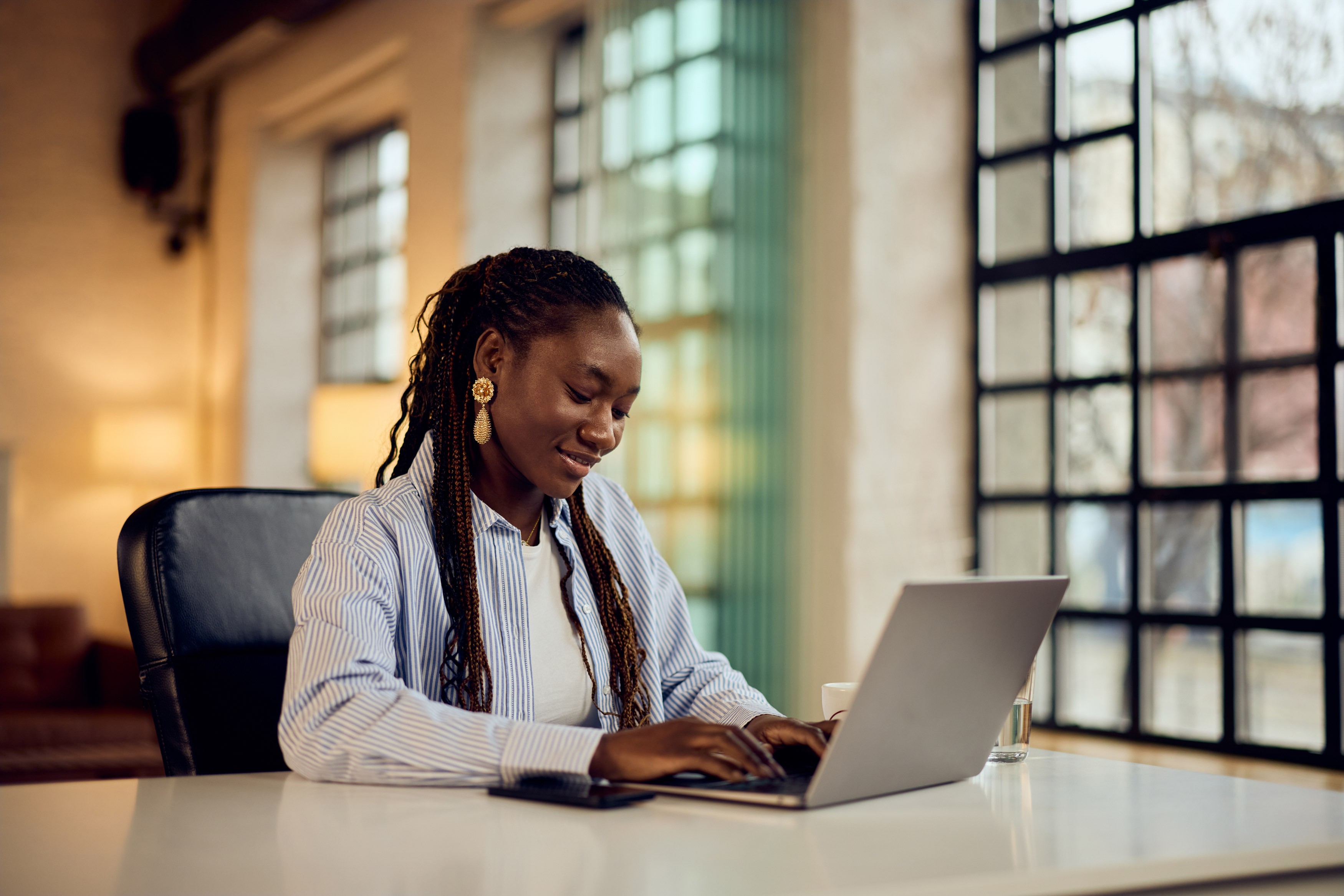 Une jeune femme travaillant sur son laptop
