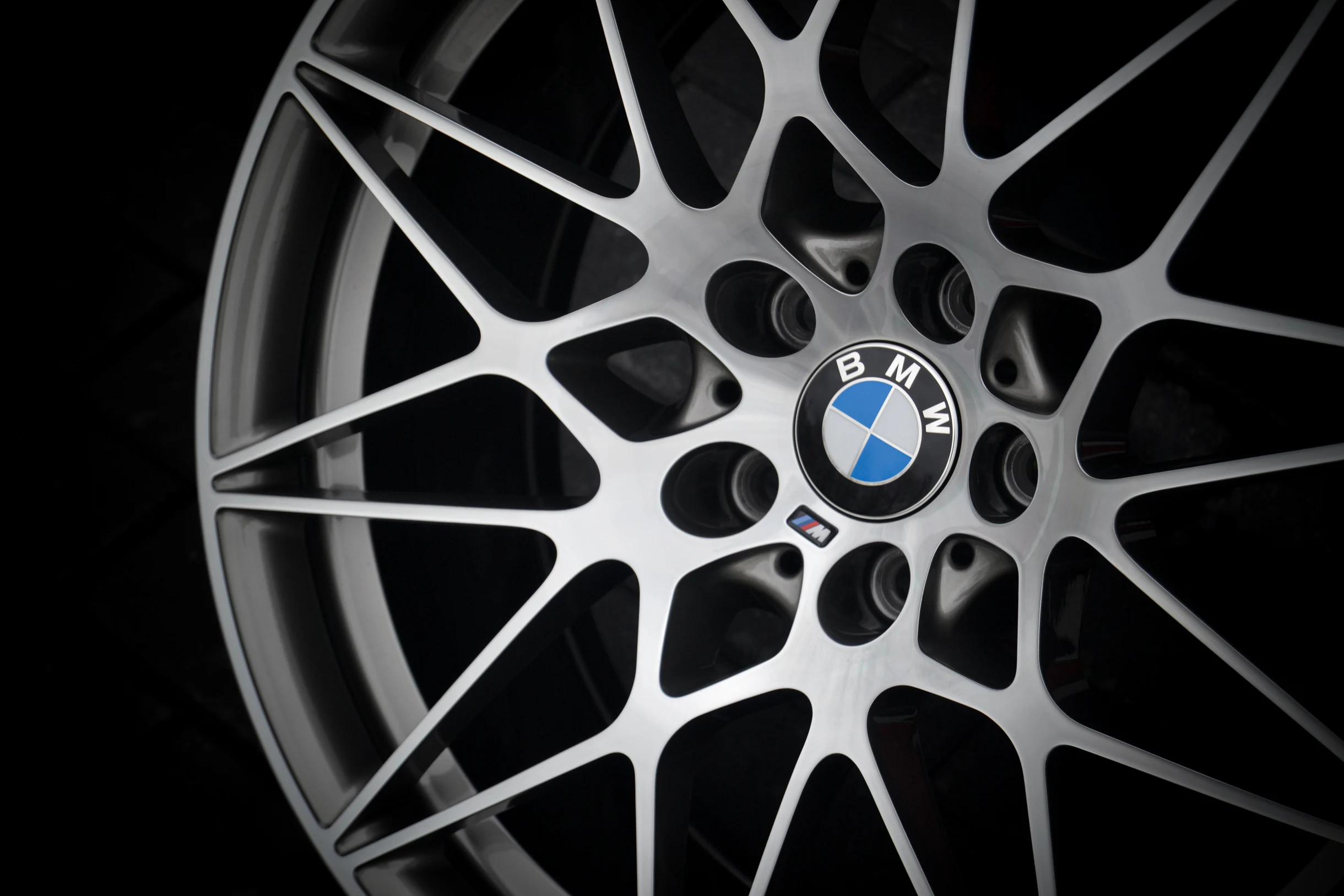 Detail der glanzgedrehten Kreuzspeichen und des BMW-Nabendeckels bei AT Plus.