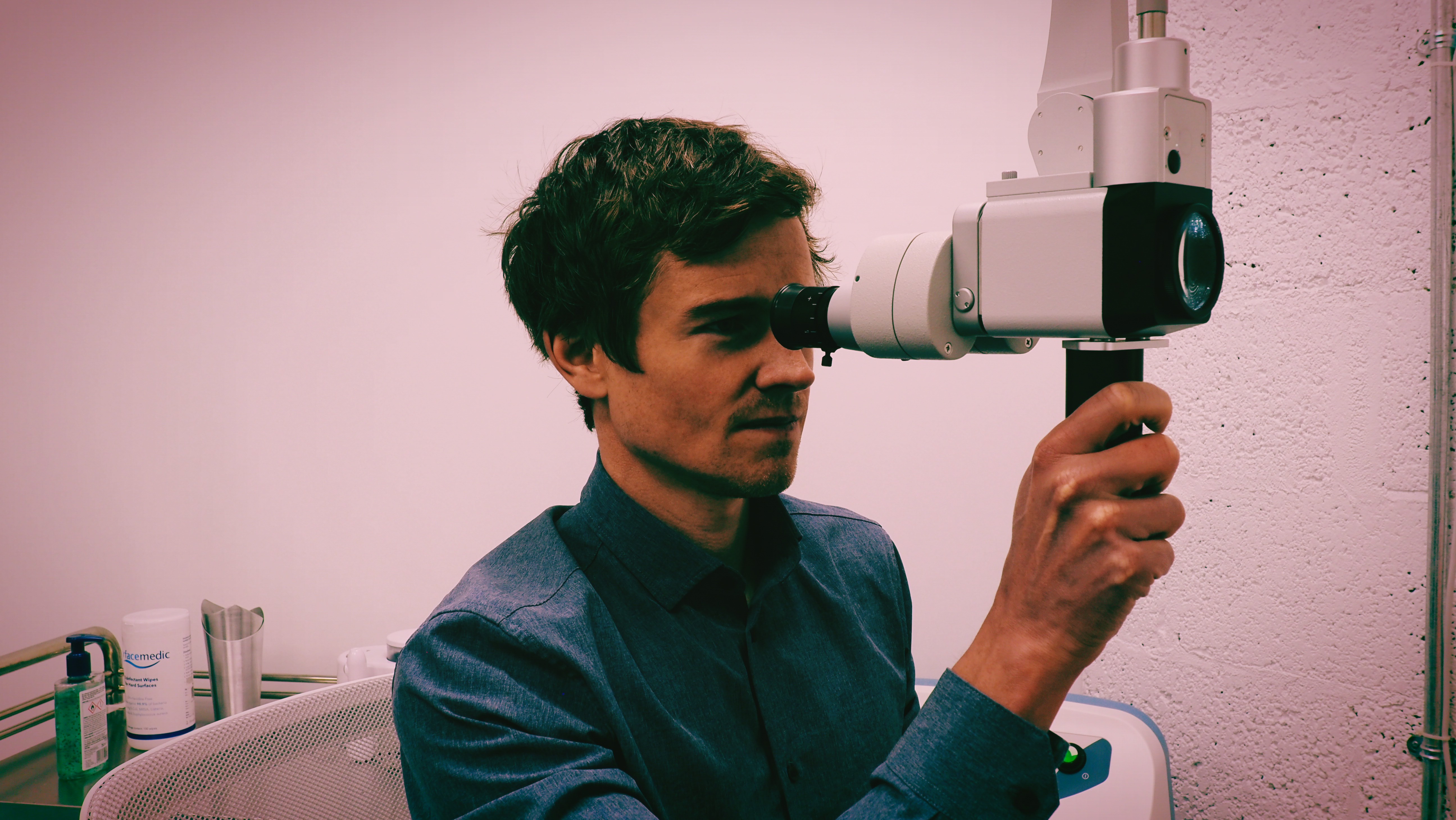 A man having his ears checked with an iPhone otoscope.
