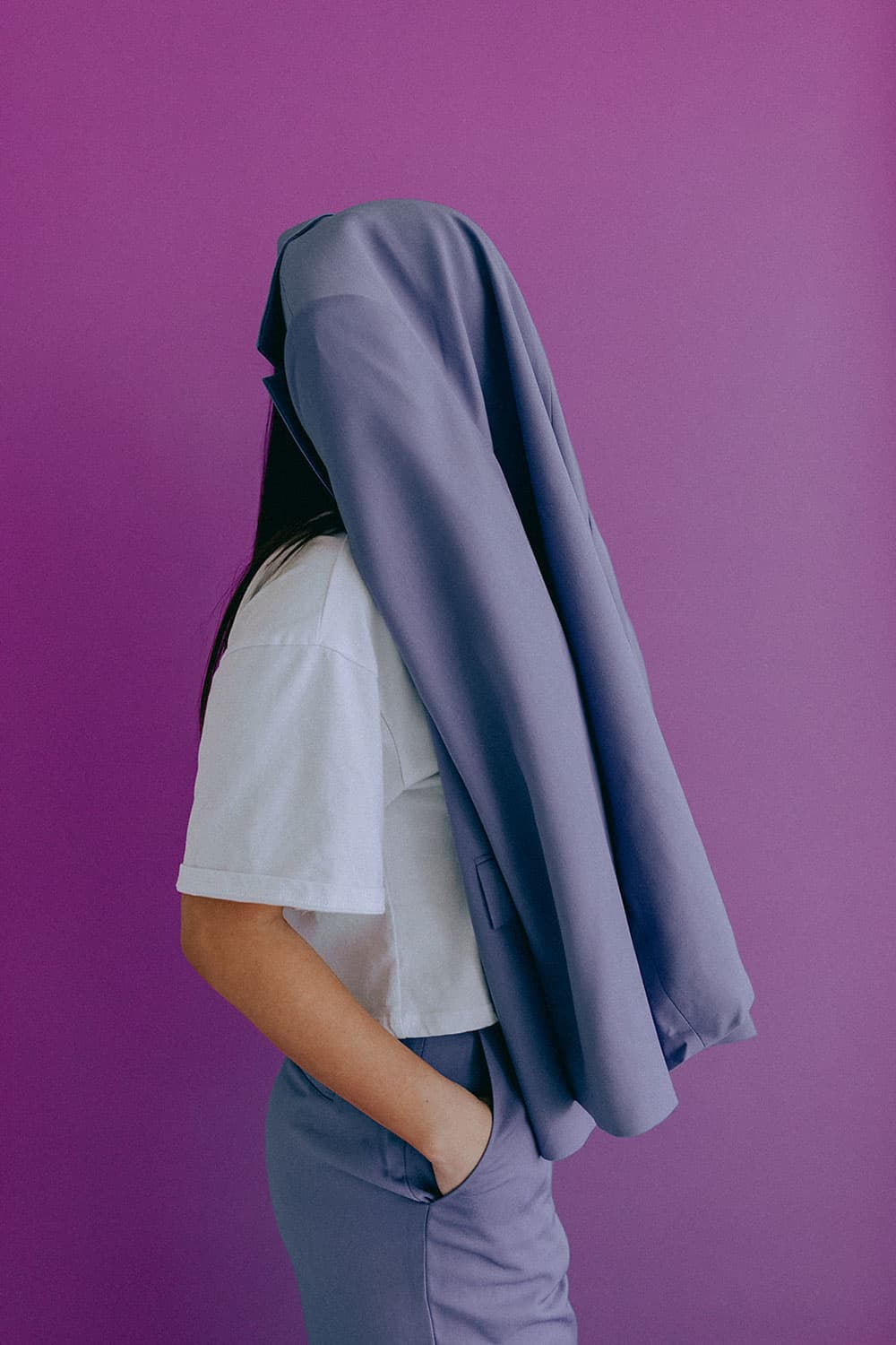 Person with towel over head with purple backdrop