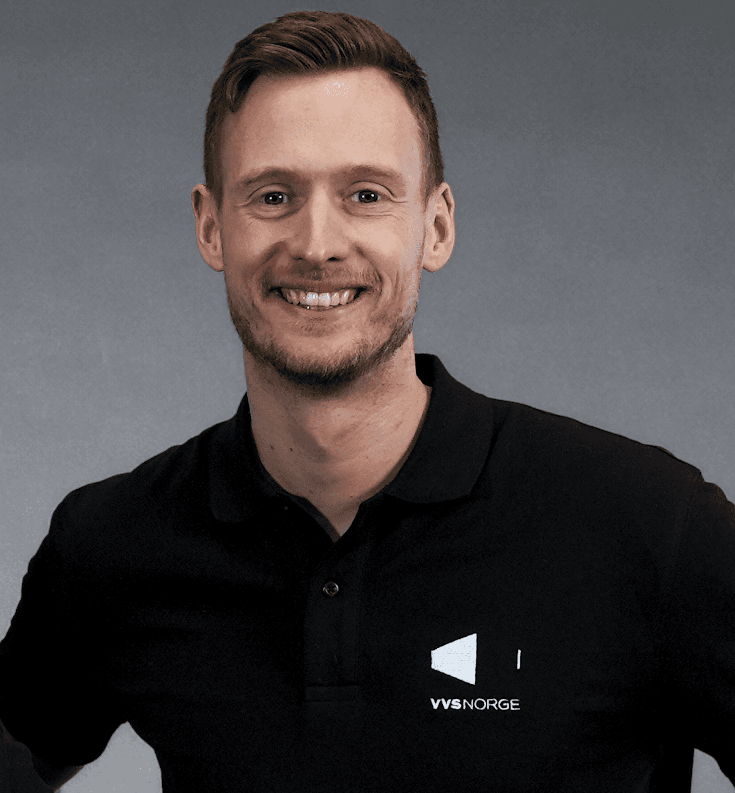 Blid mann i sort piquet med hvit VVS Norge logo på grå bakgrunn
