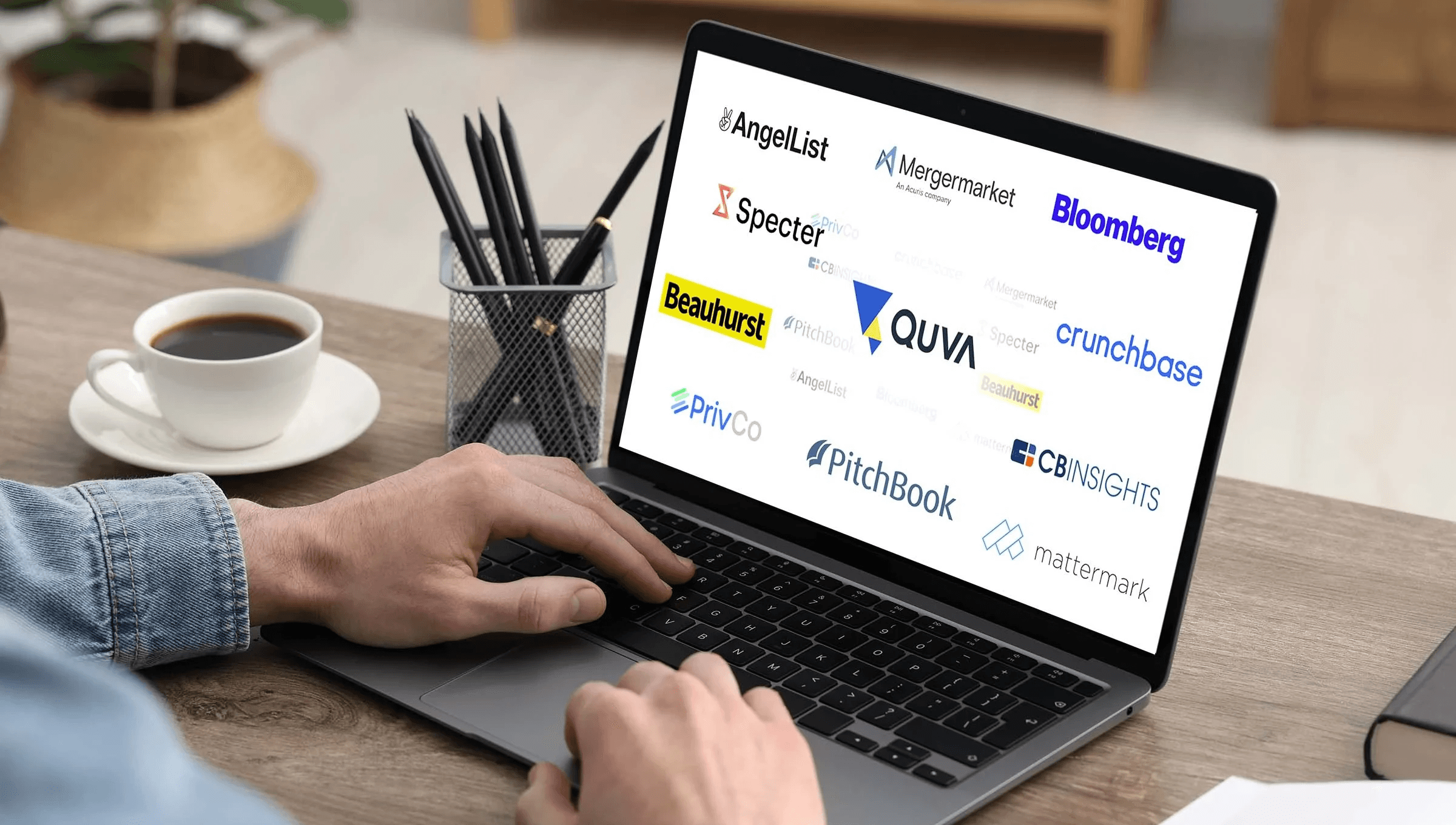 Man typing on laptop displaying logos - Alternatives for CB Insights and Pitchbook