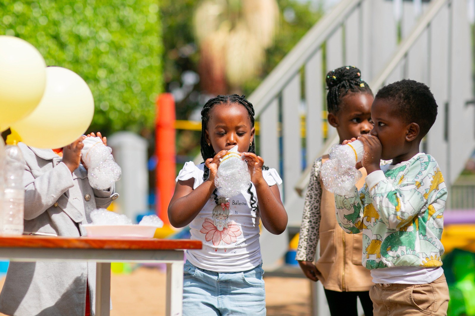 A student wearing a red uniform sits while holding a book in his hands