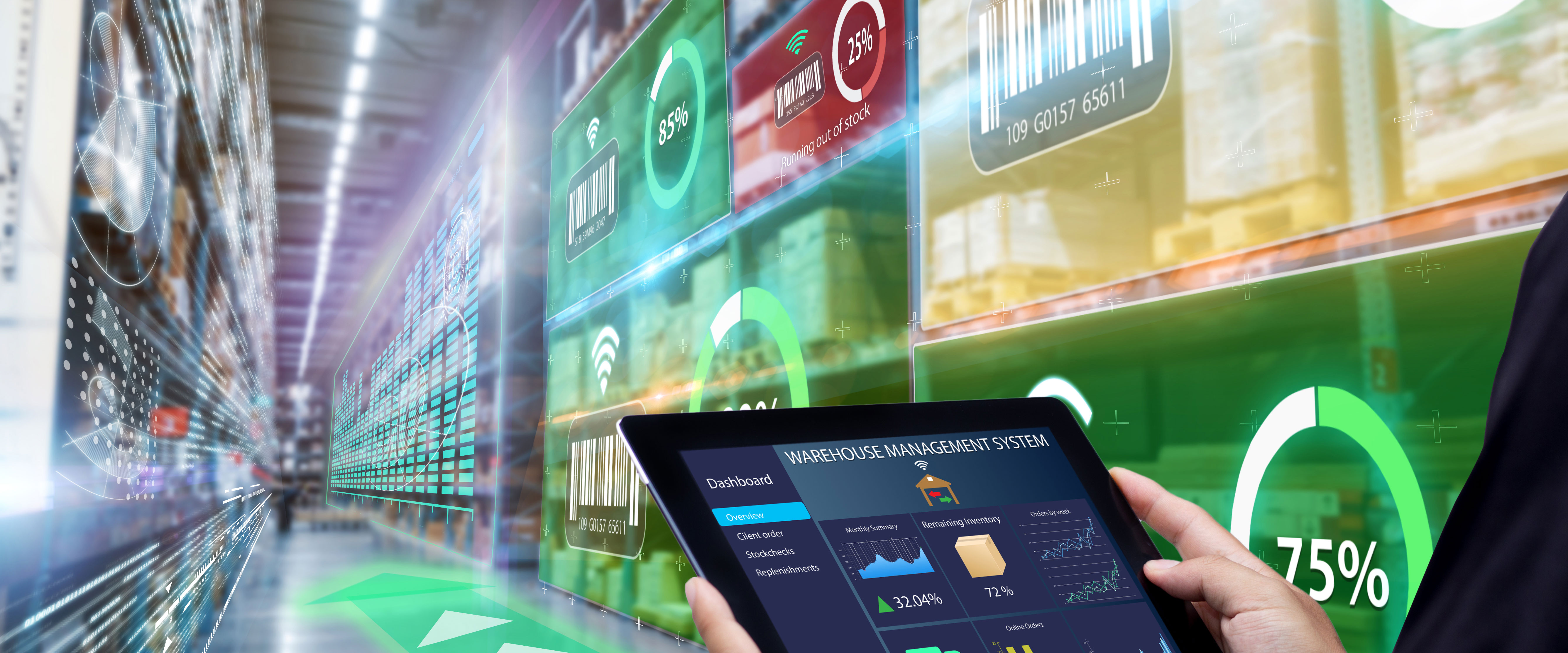 A person holds a tablet while large, colorful digital displays show data and graphics in a modern setting.