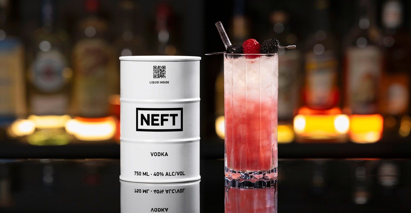A NEFT Barrel and a glass of Almond Berry Spritz on a bar counter.