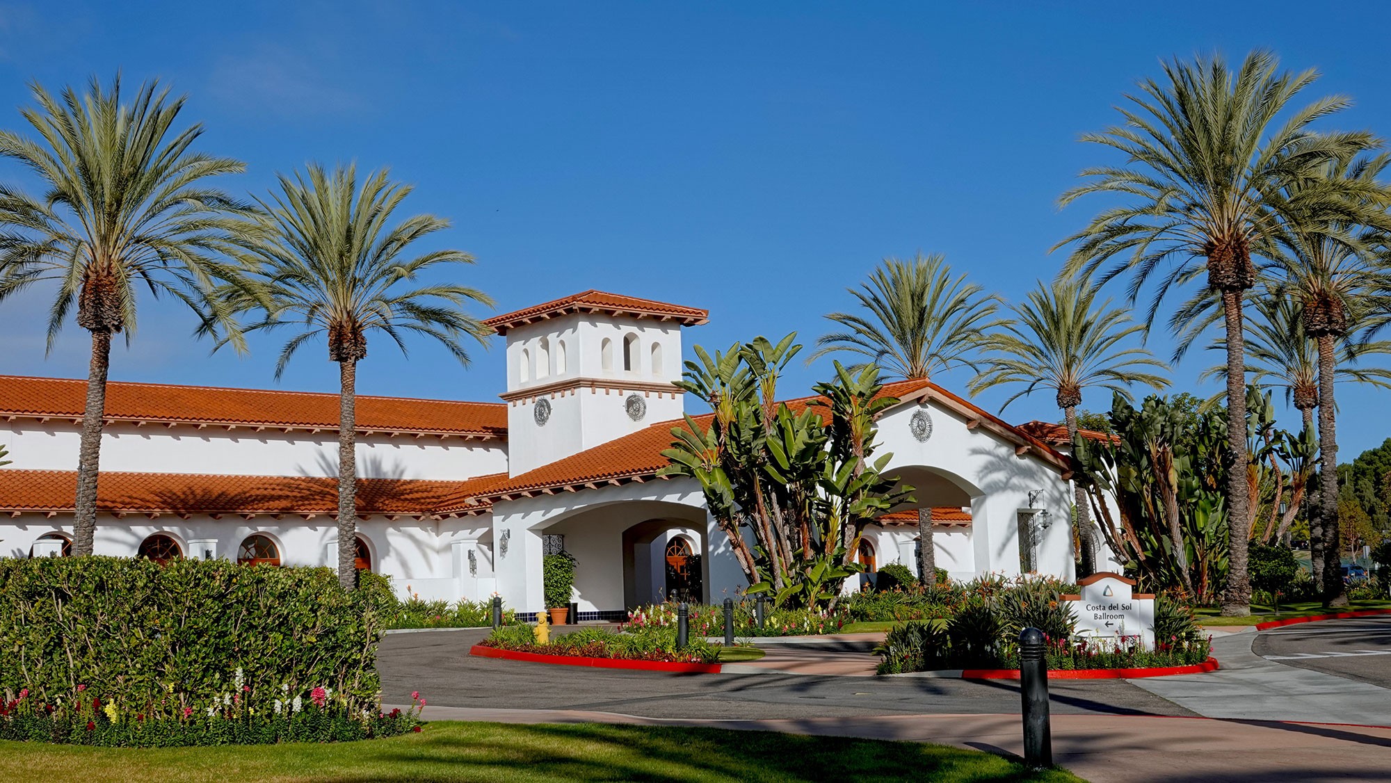 Outside view of Omni La Costa Resort, palm trees and blue sky