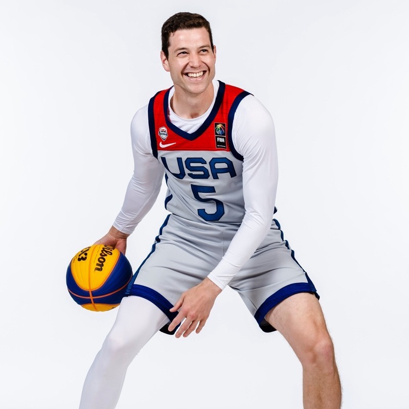 Portrait of a person in a pink sweater against a light background