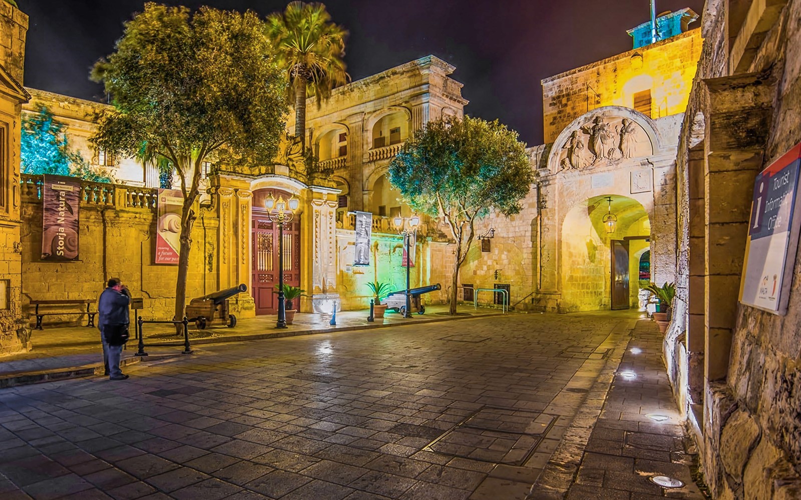 Historic street in Malta illuminated at night during a guided tour.