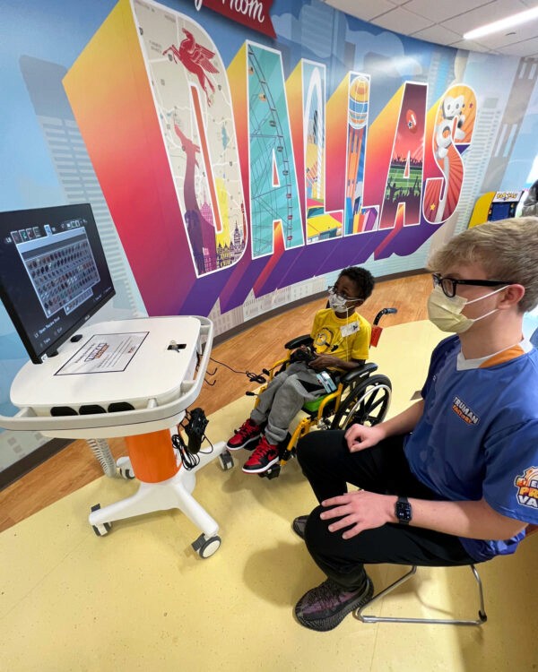 Truman at Dallas Childrens hospital playing games on a GO Kart with a patient.