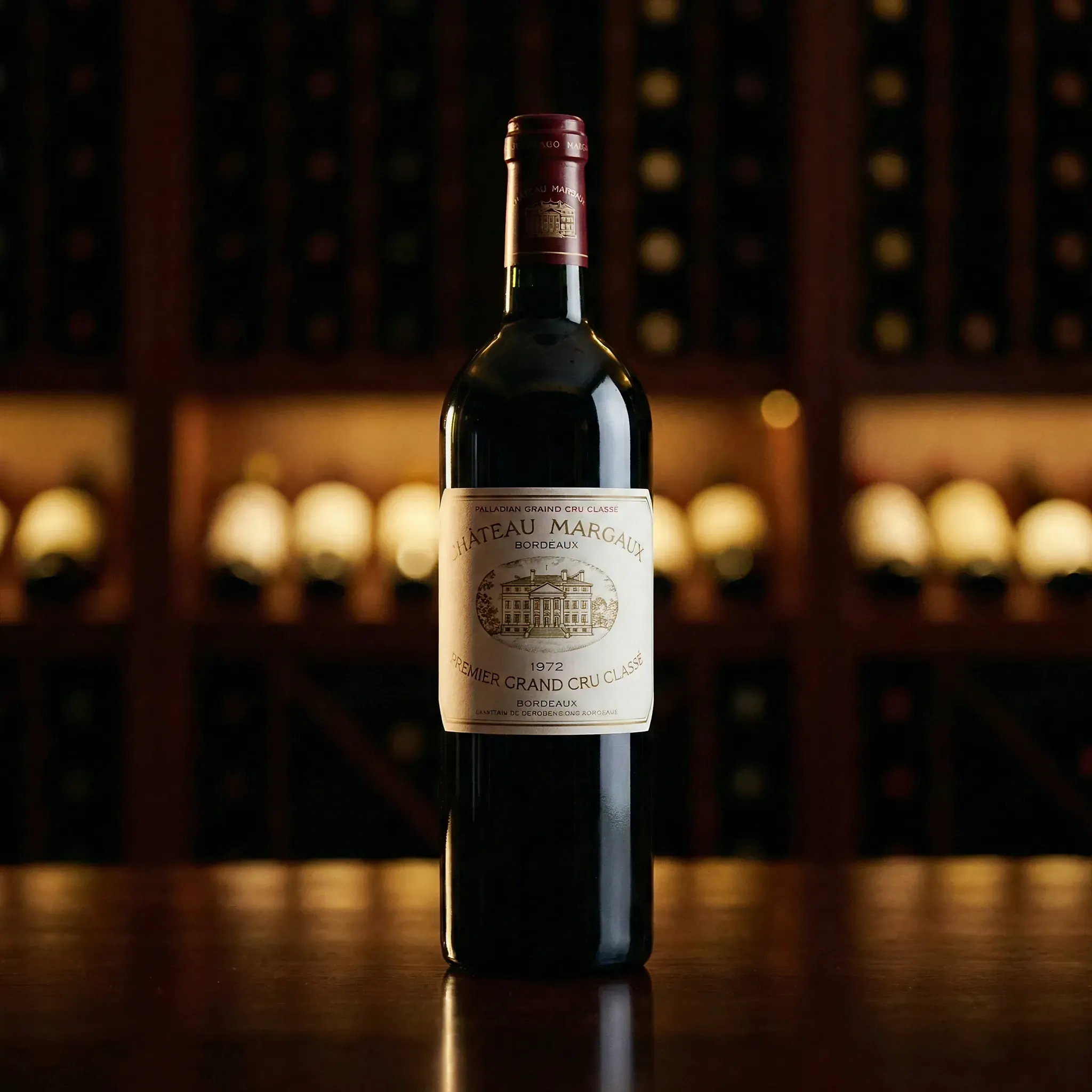 A bottle of 1972 Château Margaux wine stands on a wooden table, with a softly blurred wine rack in the dimly lit background, exuding elegance.