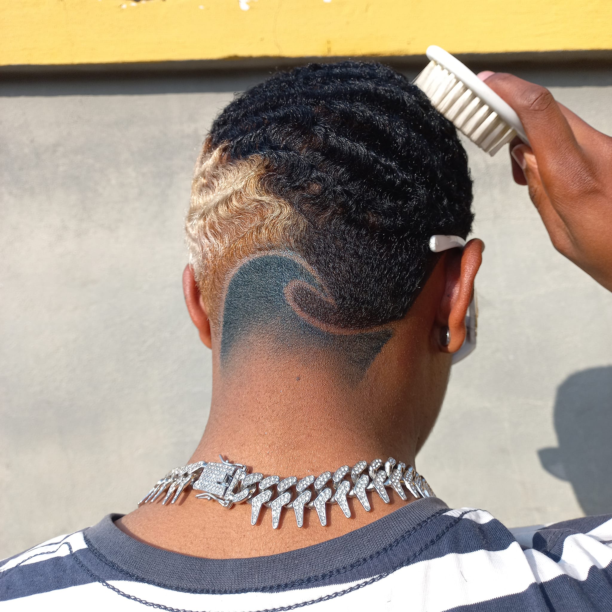 A haircut with a wave pattern as well as dye applied to the hair