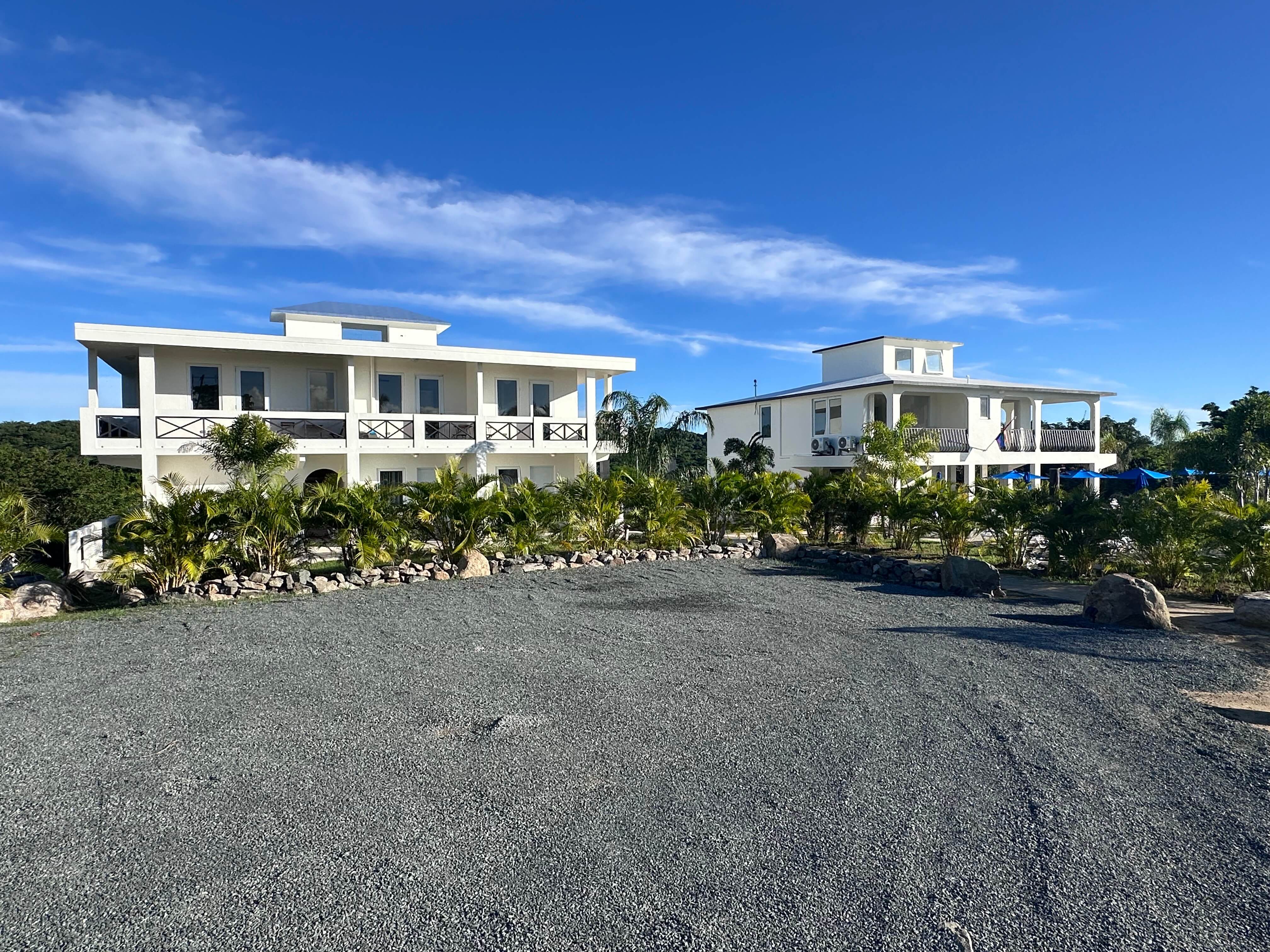 Exterior view of Club Vieques resort building with private balconies, lush landscaping, and beautiful Caribbean sunset lighting.