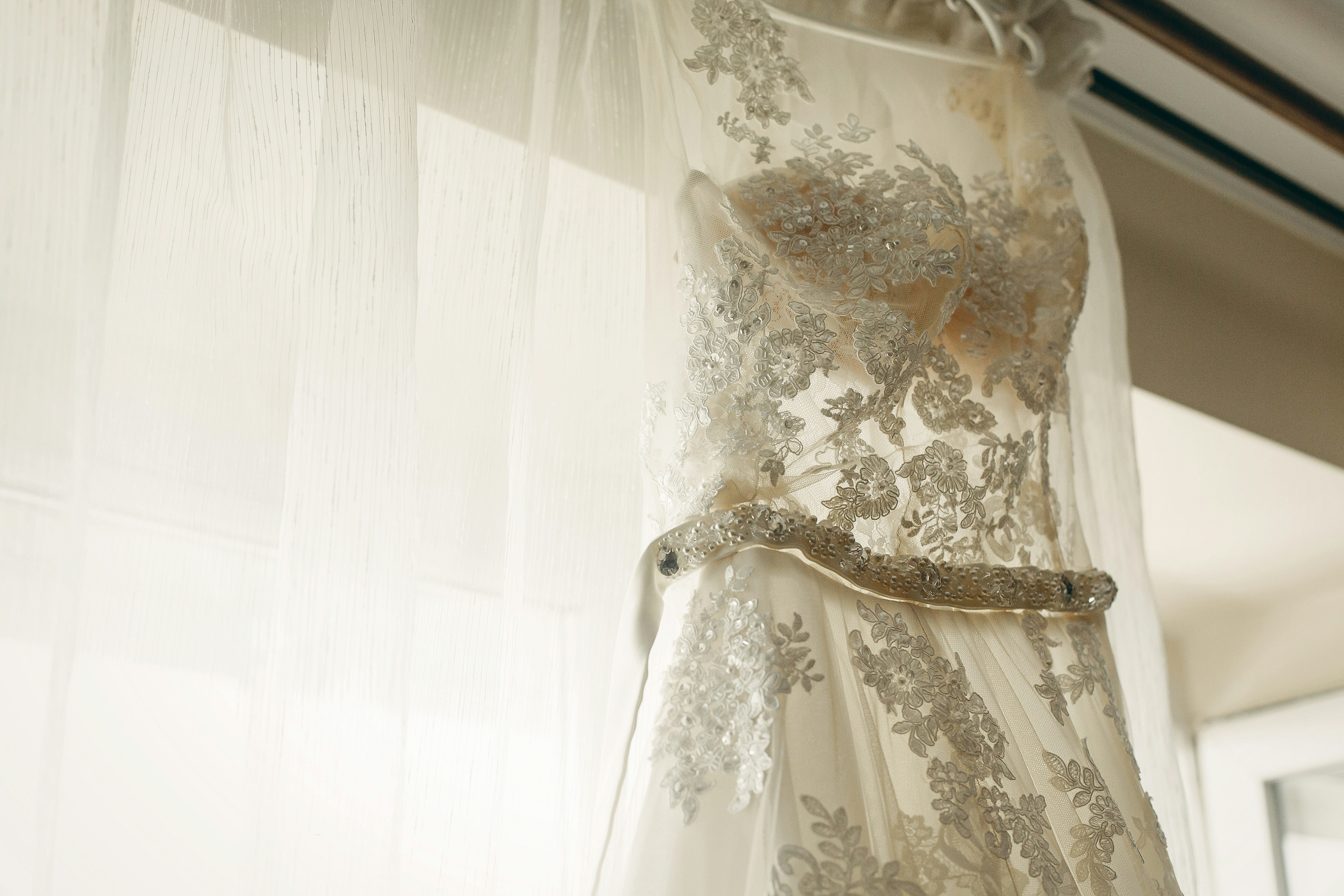 Elegant bridal gown hanging on a hanger before the ceremony.
