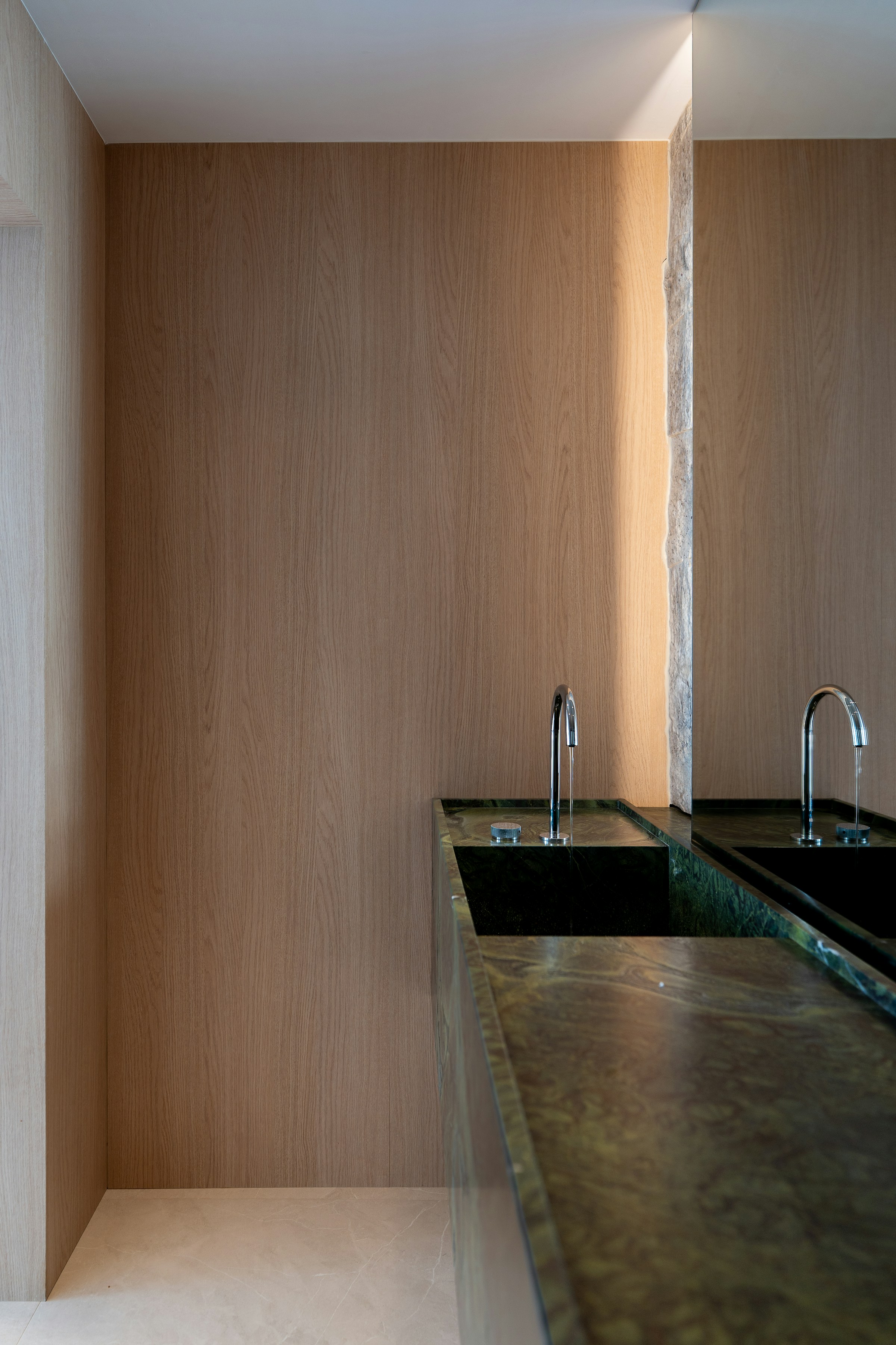 Headland Retreat, Green marble counter with two sinks in a modern bathroom