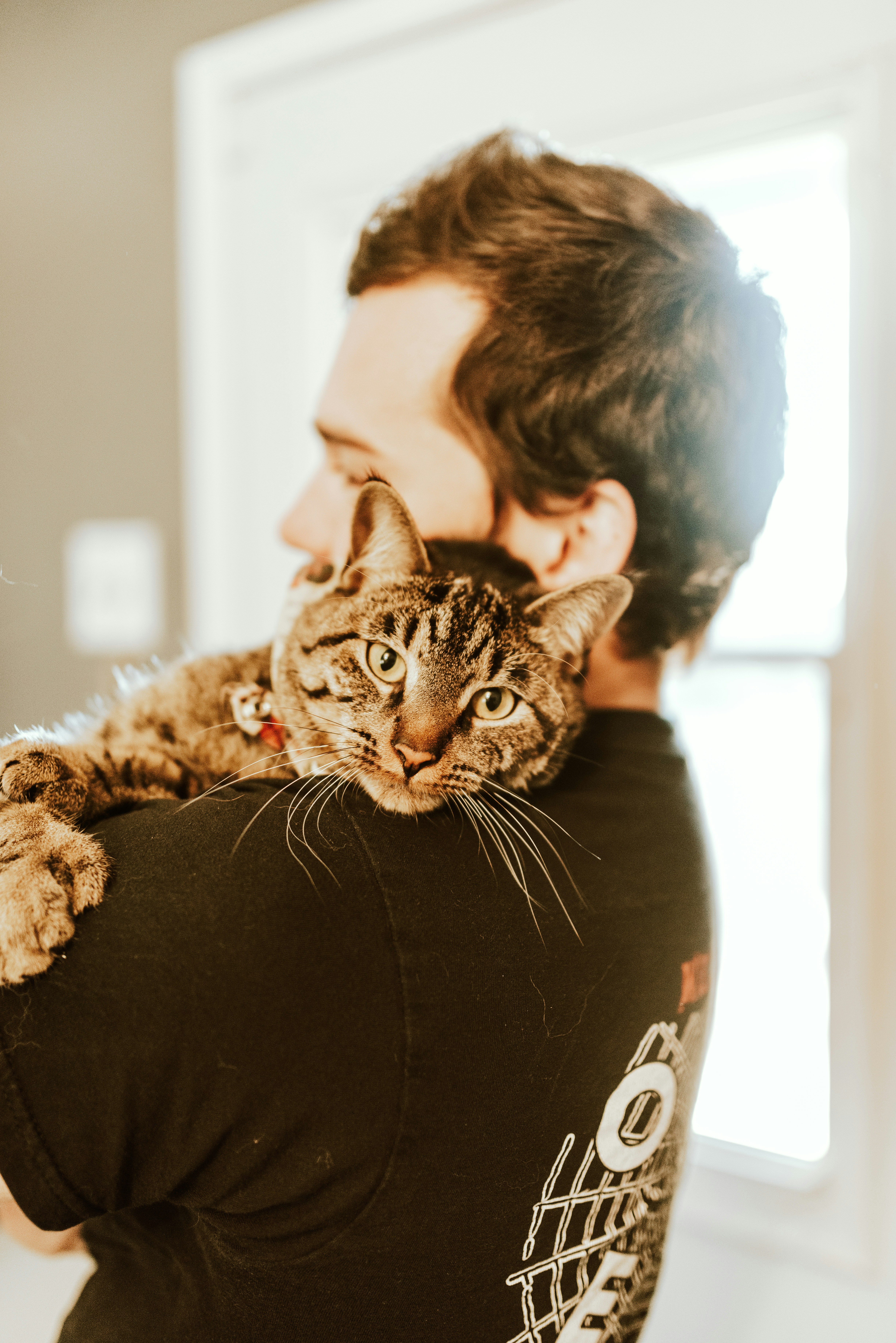 Picture of a young man holding a cat in his arms