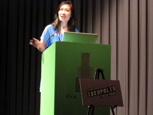 a student giving a speech from the green stand in the amphitheater