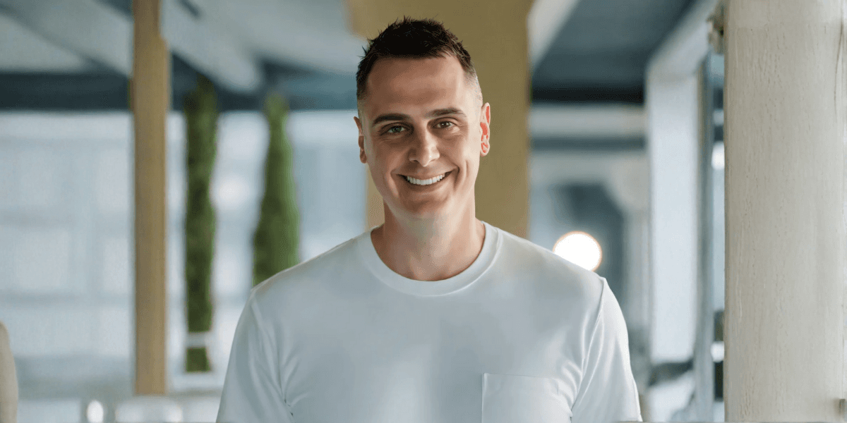 A smiling man in a white shirt looks directly at the camera, representing BOLDER Digital's approachable and innovative ethos.