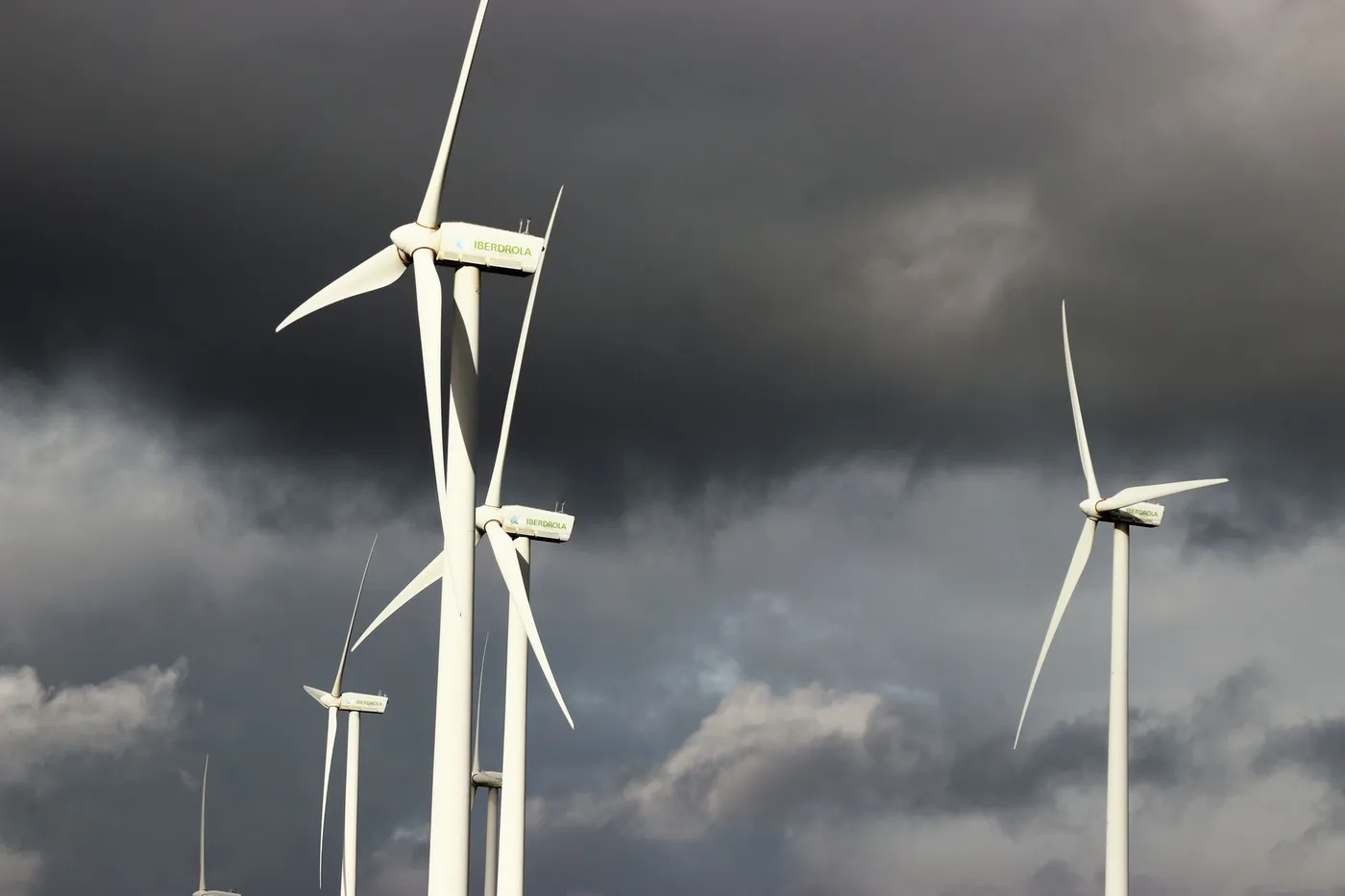 Wind turbines on a ridge under dark storm clouds