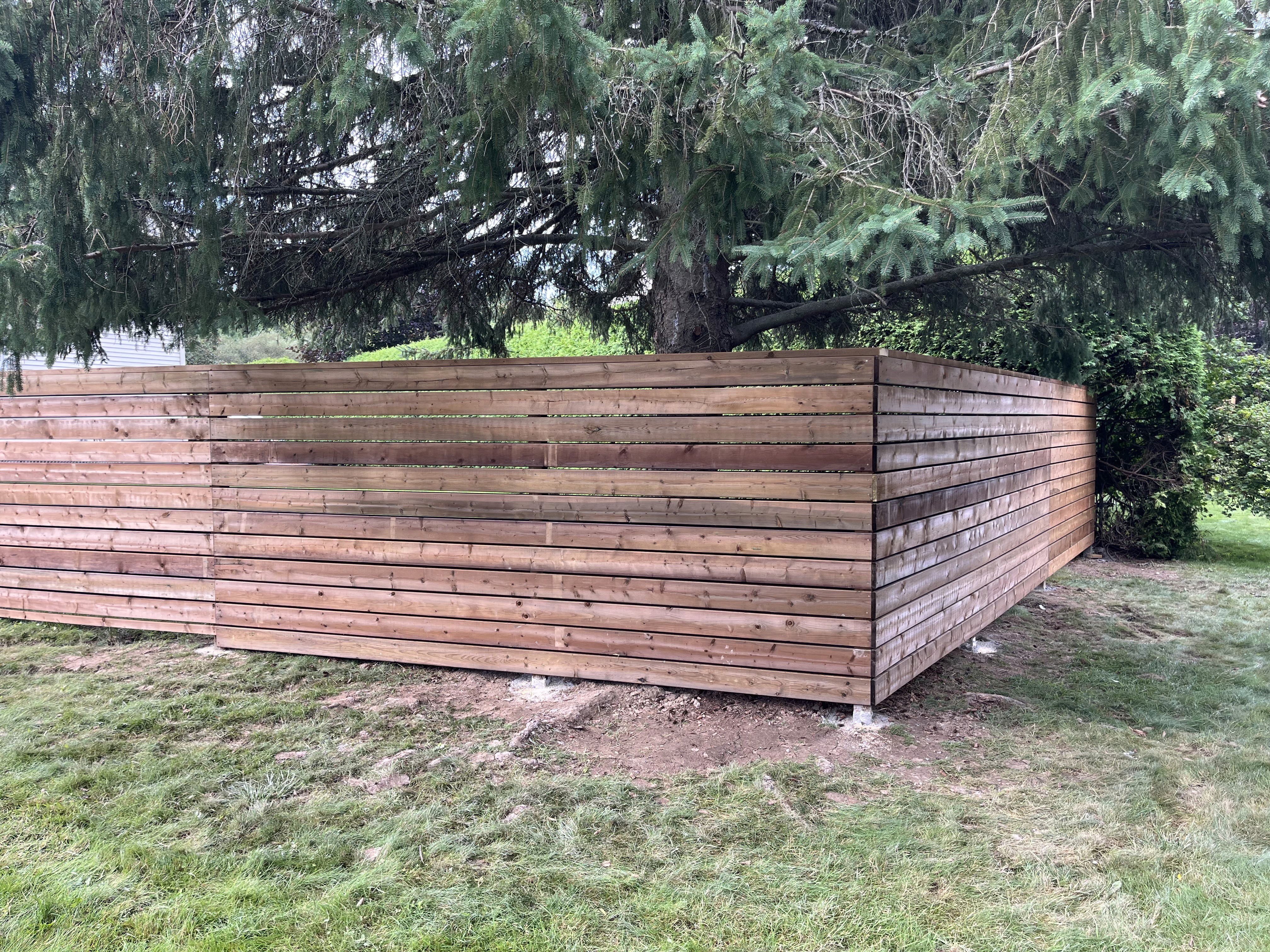 Before and after professionally stained fence enhancing outdoor space in Ottawa