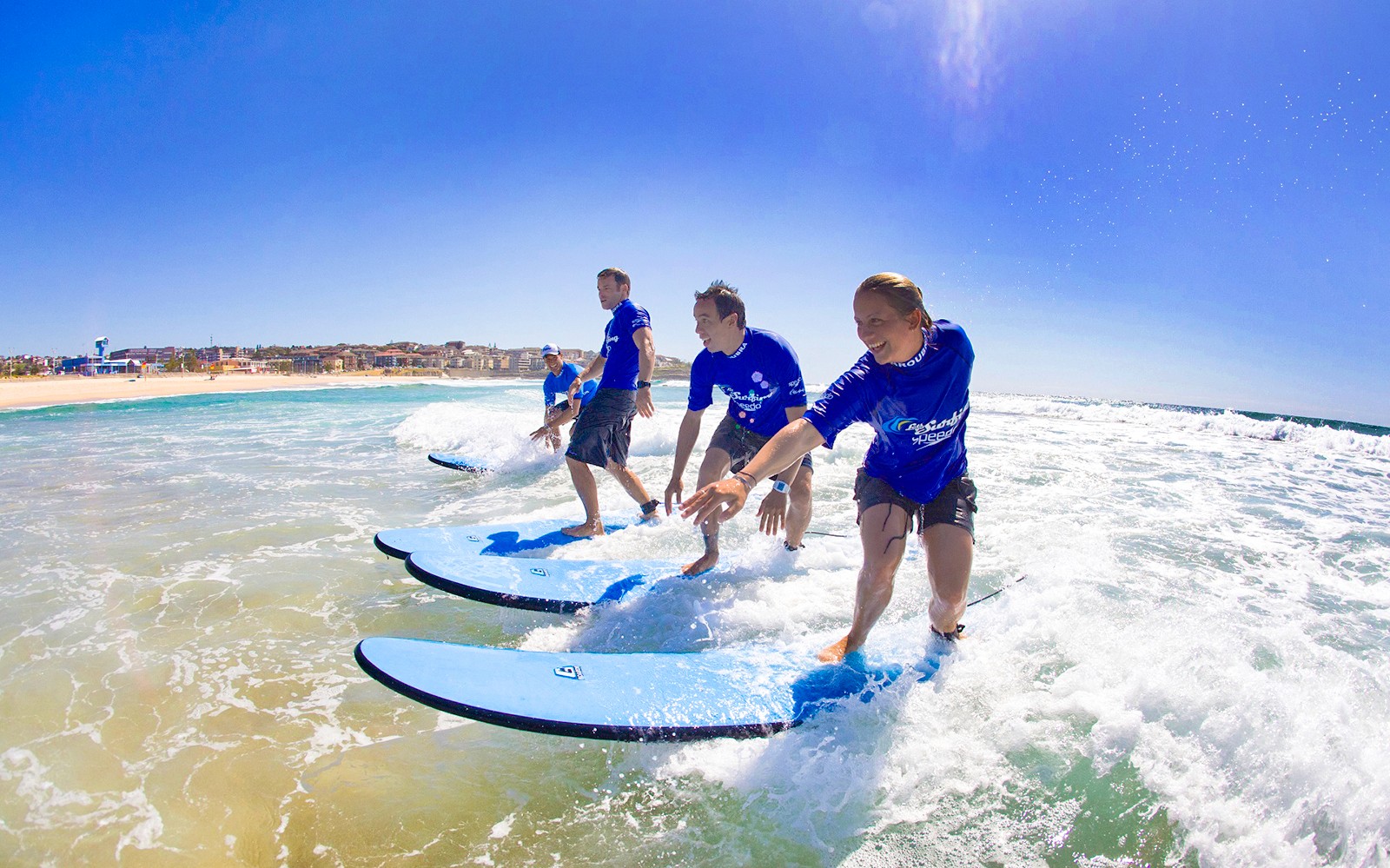 Surfisti che imparano a cavalcare le onde durante una lezione a Maroubra Beach, Sydney.