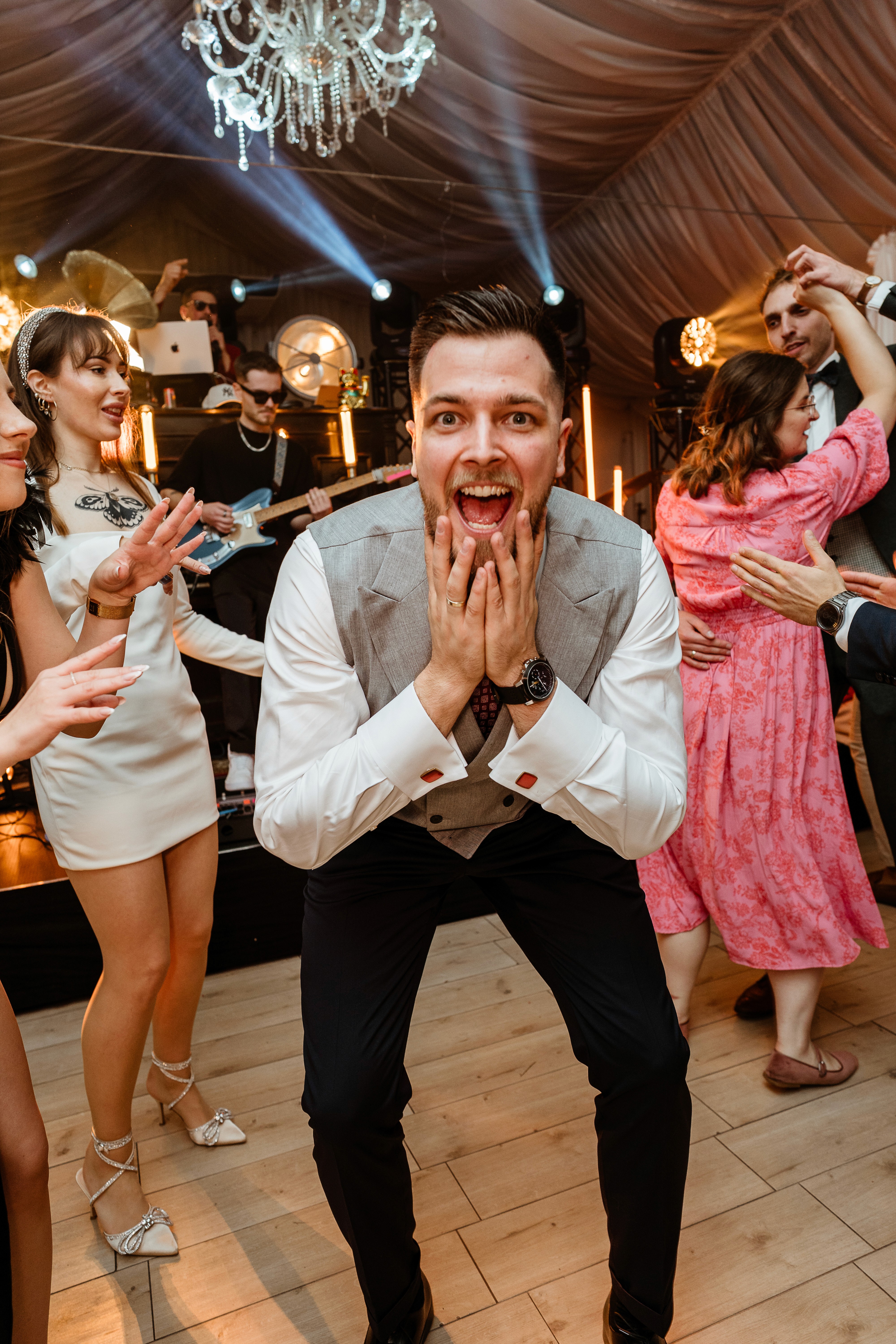 A person with short blonde hair holds a vintage camera.