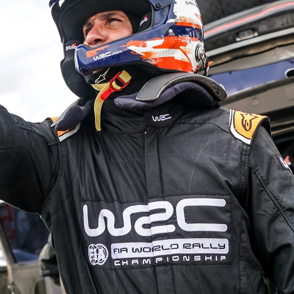 Man wearing rally car clothing and helmet
