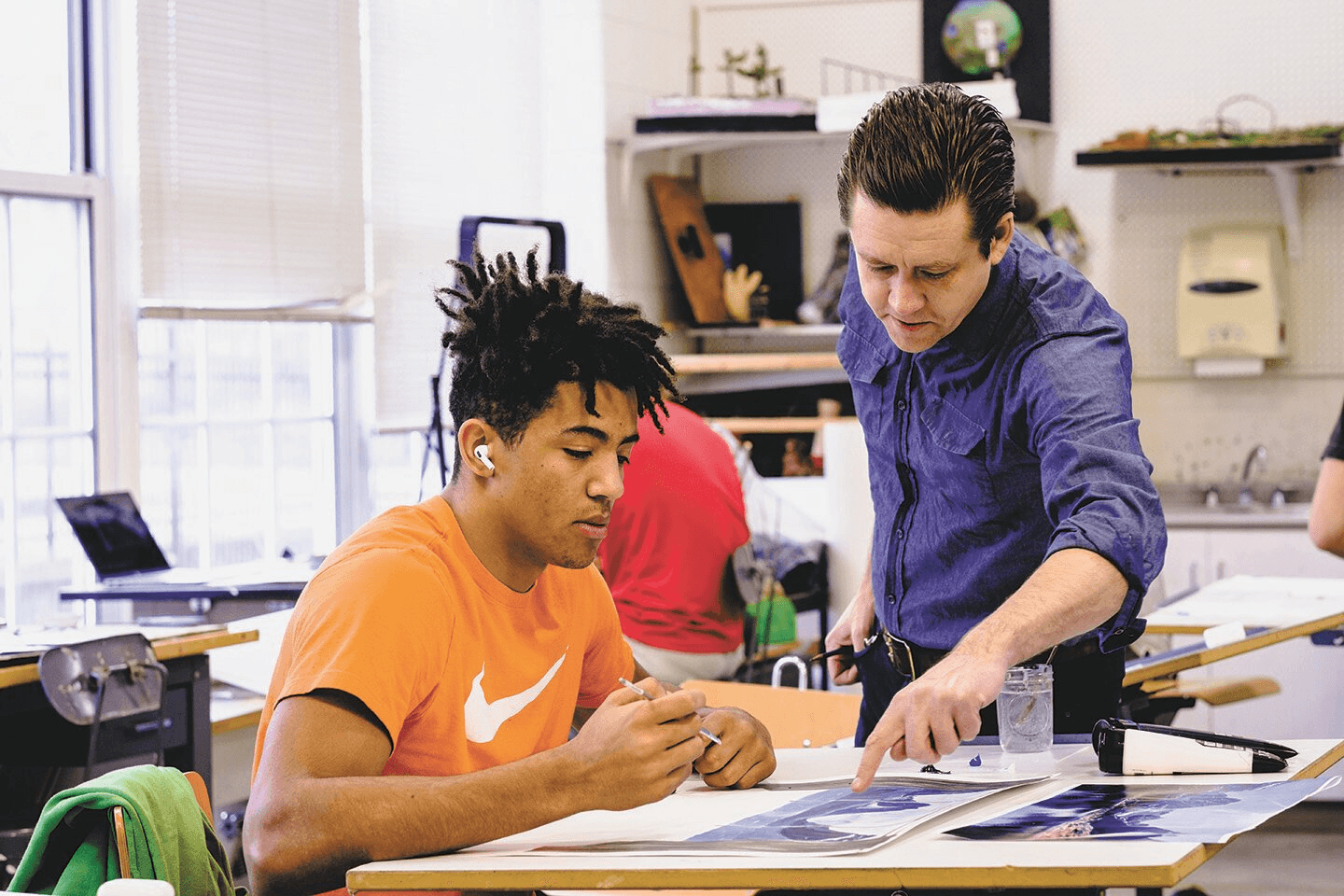 Teacher helping student with work - best alumni networks colleges